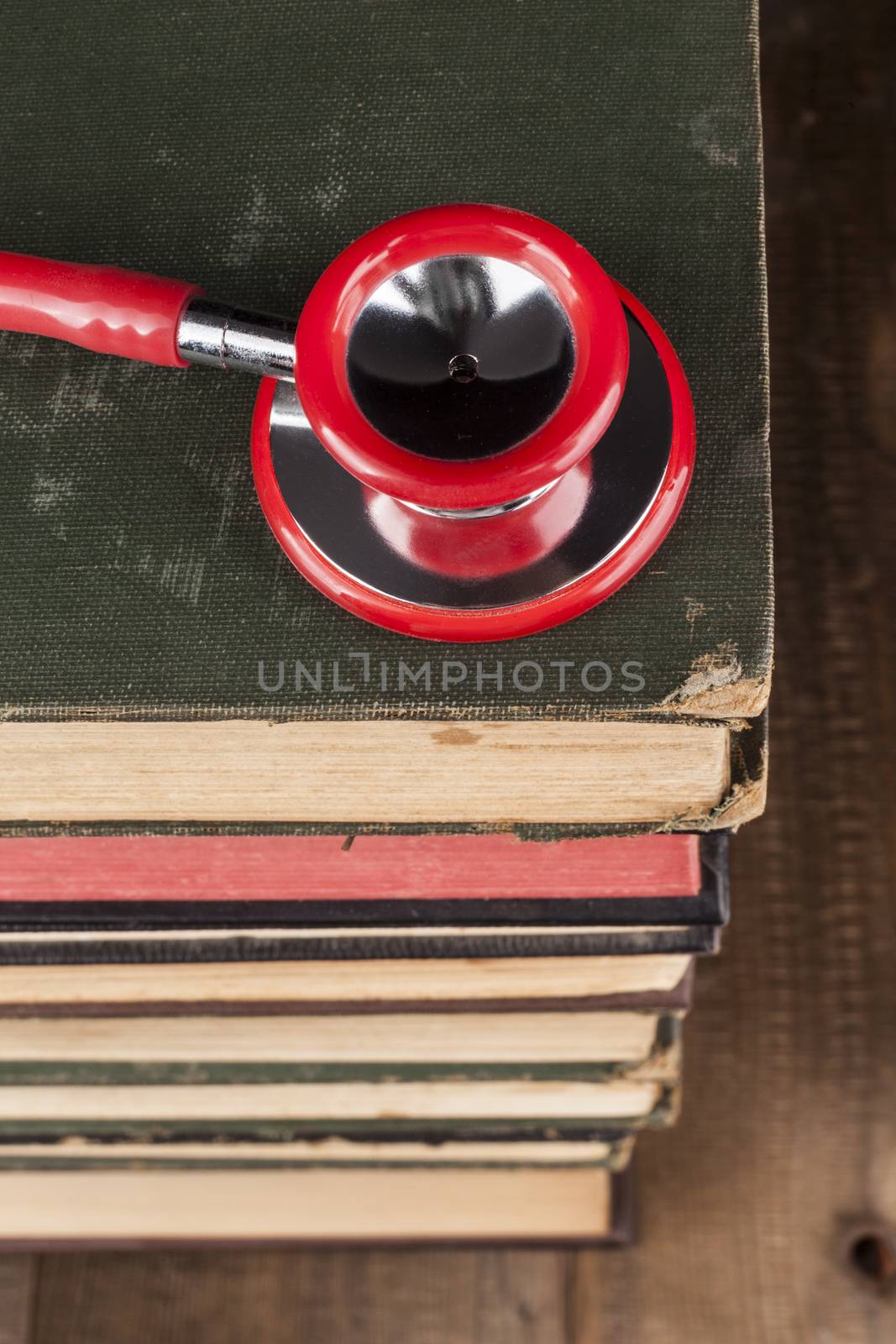 Red Stethoscope Closeup on Old Books Pile