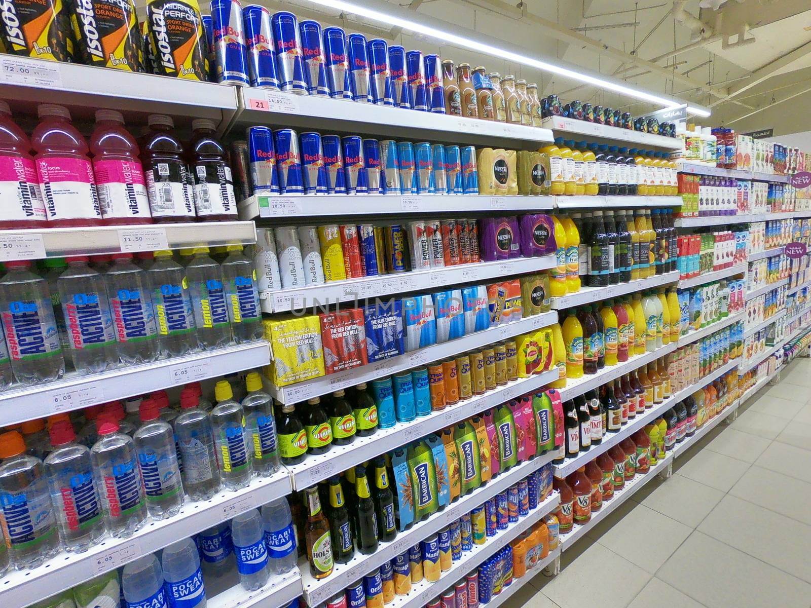 Aisle in Supermarket displaying energy drinks, juice bottles.
