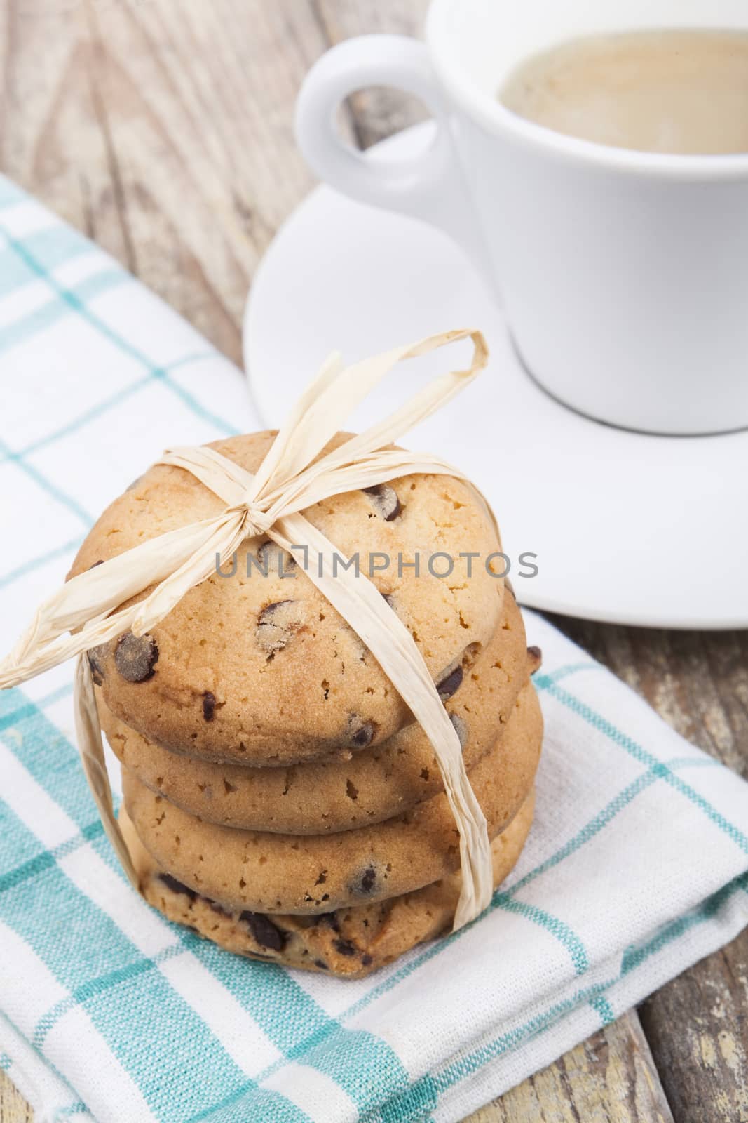 Chocolate chip cookies with coffee on brown wood background