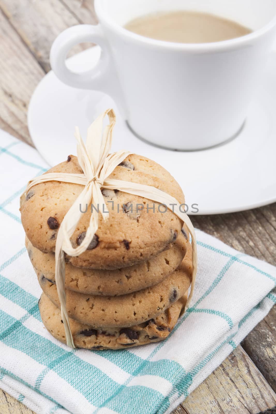 Chocolate chip cookies with coffee on brown wood background