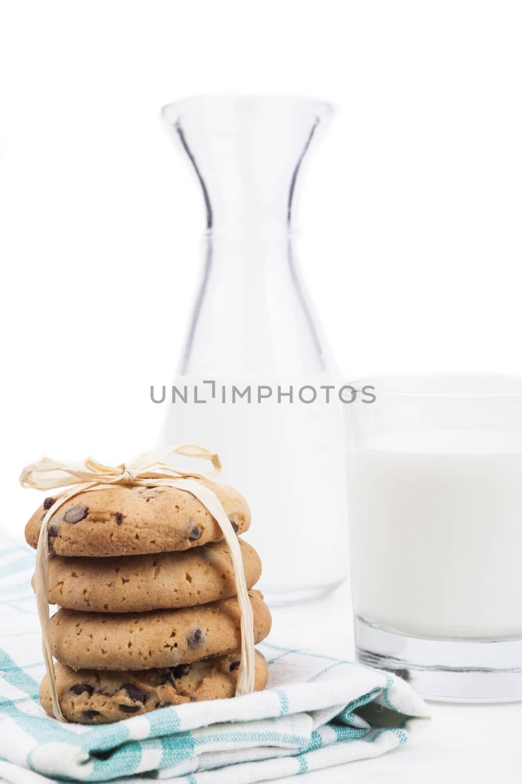 Glass of milk and chocolate chips cookies on white background