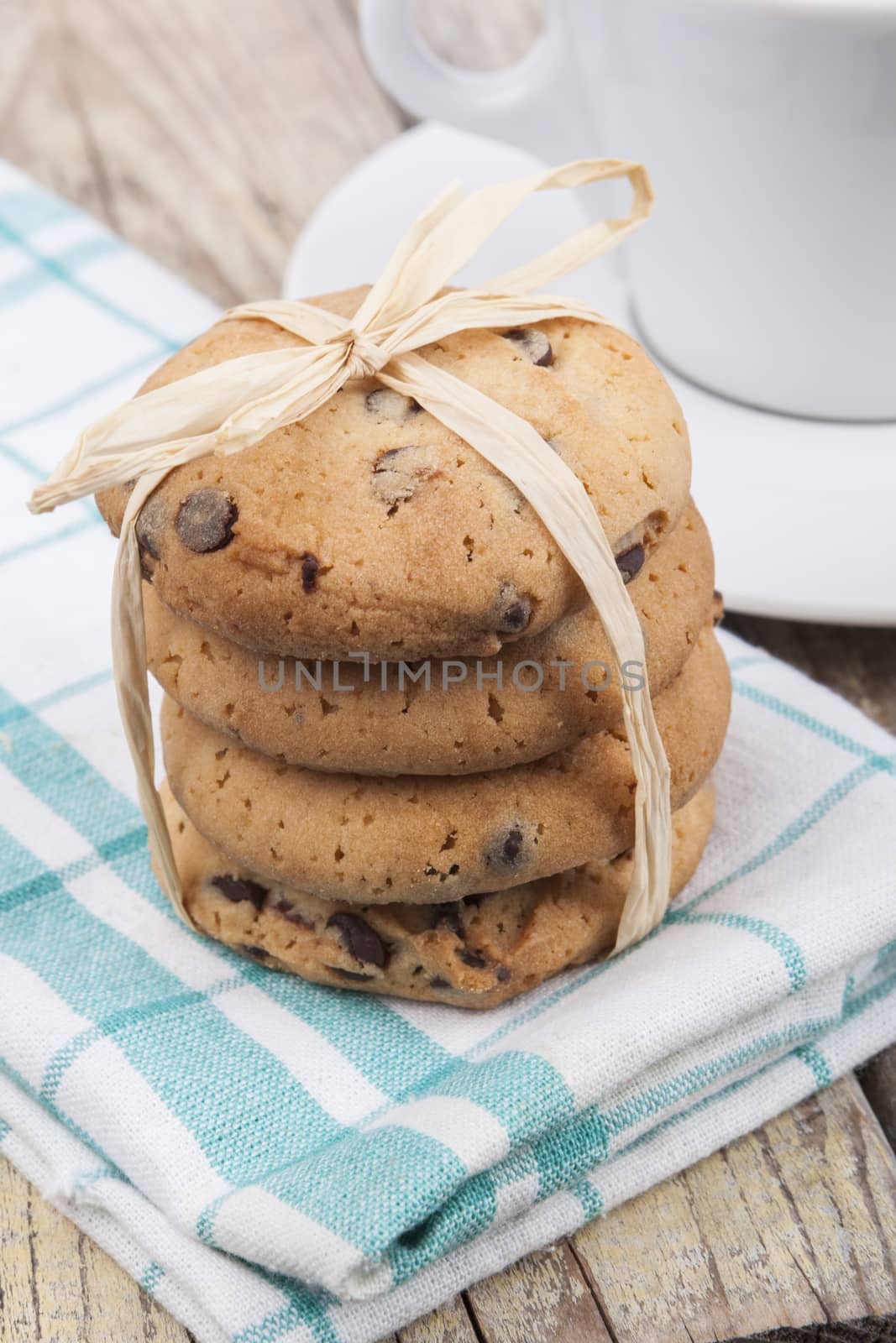 Chocolate chip cookies with coffee on brown wood background