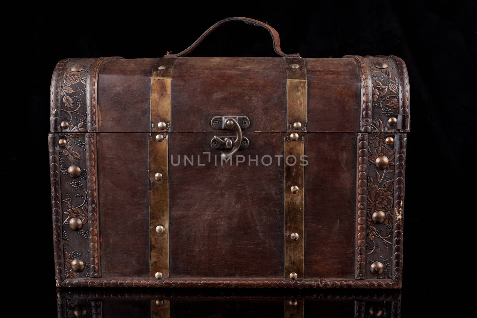 Old wood chest closed isolated on black background with reflection