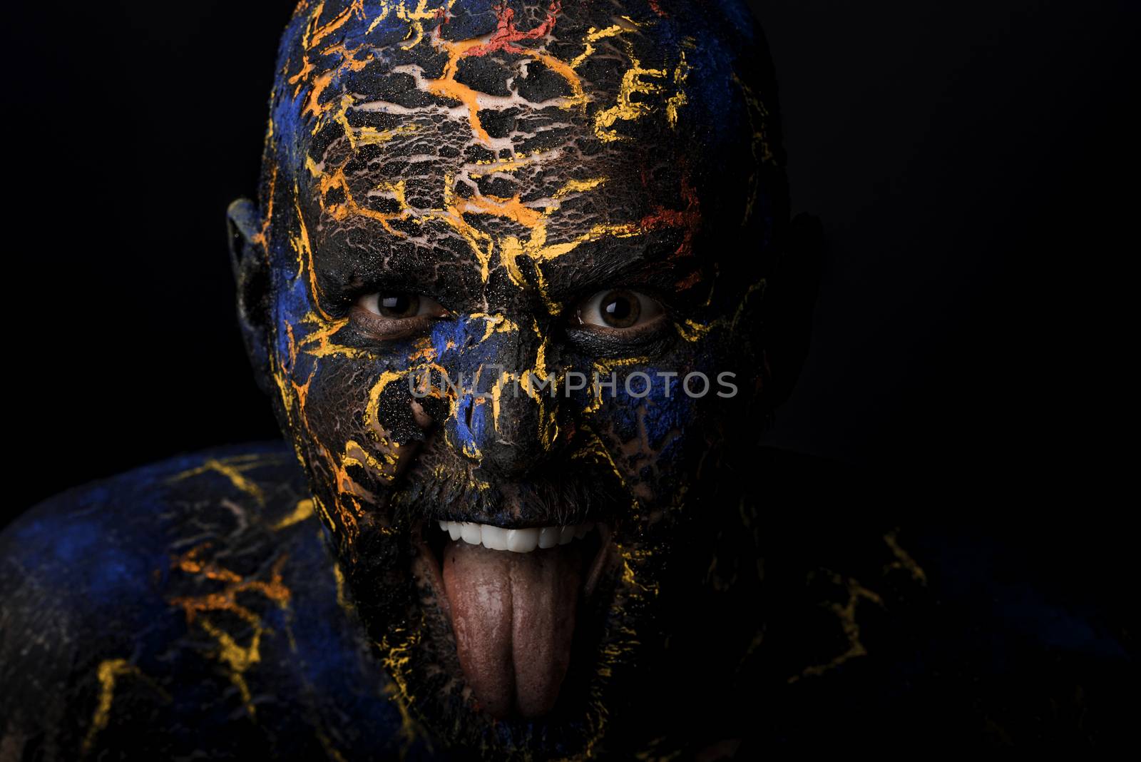 Conceptual Portrait of a brutal man painted in face art style over black background