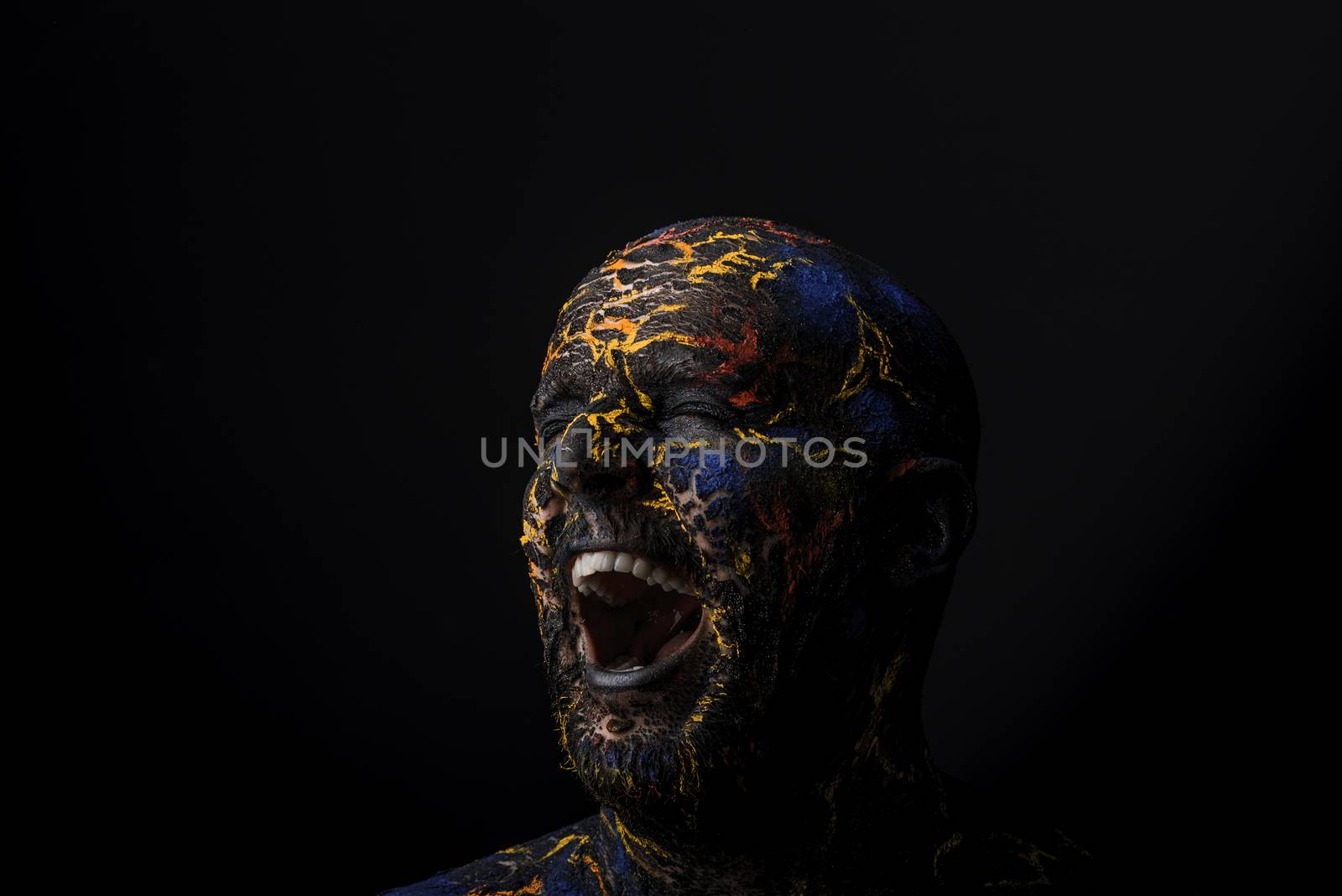 Conceptual Portrait of a brutal man painted in face art style over black background