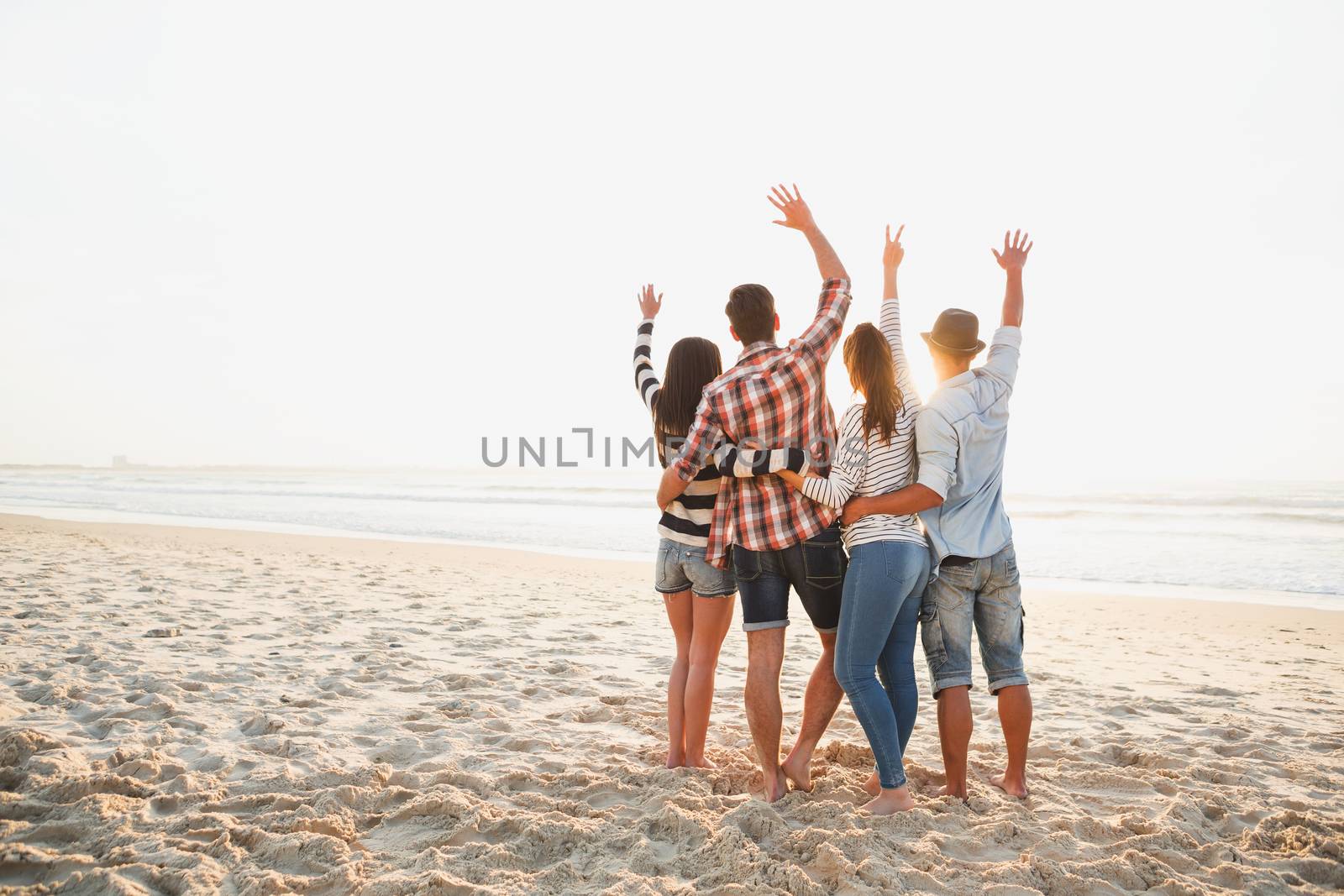 Group of friends at the beach and enjoying the sunset