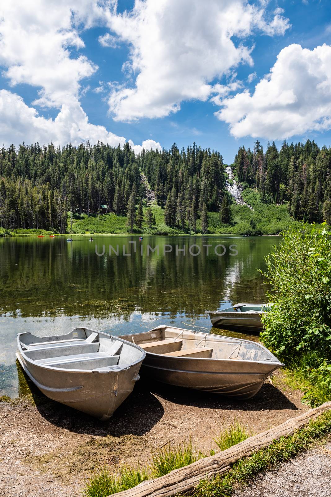 Boats docked on shore in Twin Lakes with  Twin Falls in the background in Mammoth Lakes, California by Njean