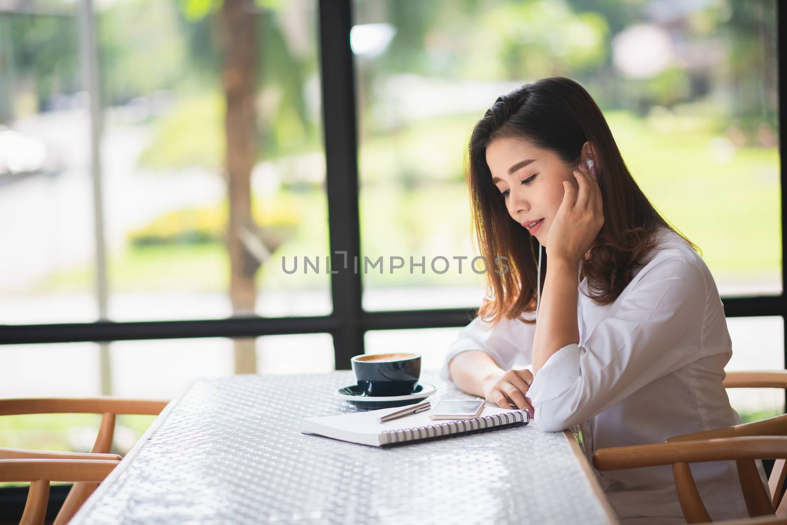 beautiful girl listen music in the cafe and drink some coffee by Wmpix