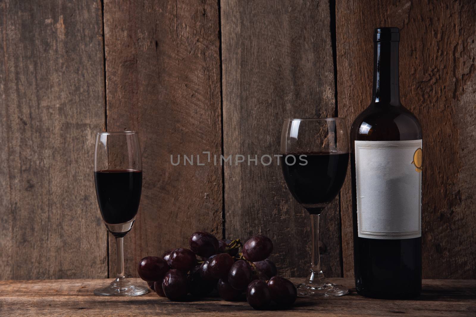 wine and grape on wood table wood background by Wmpix