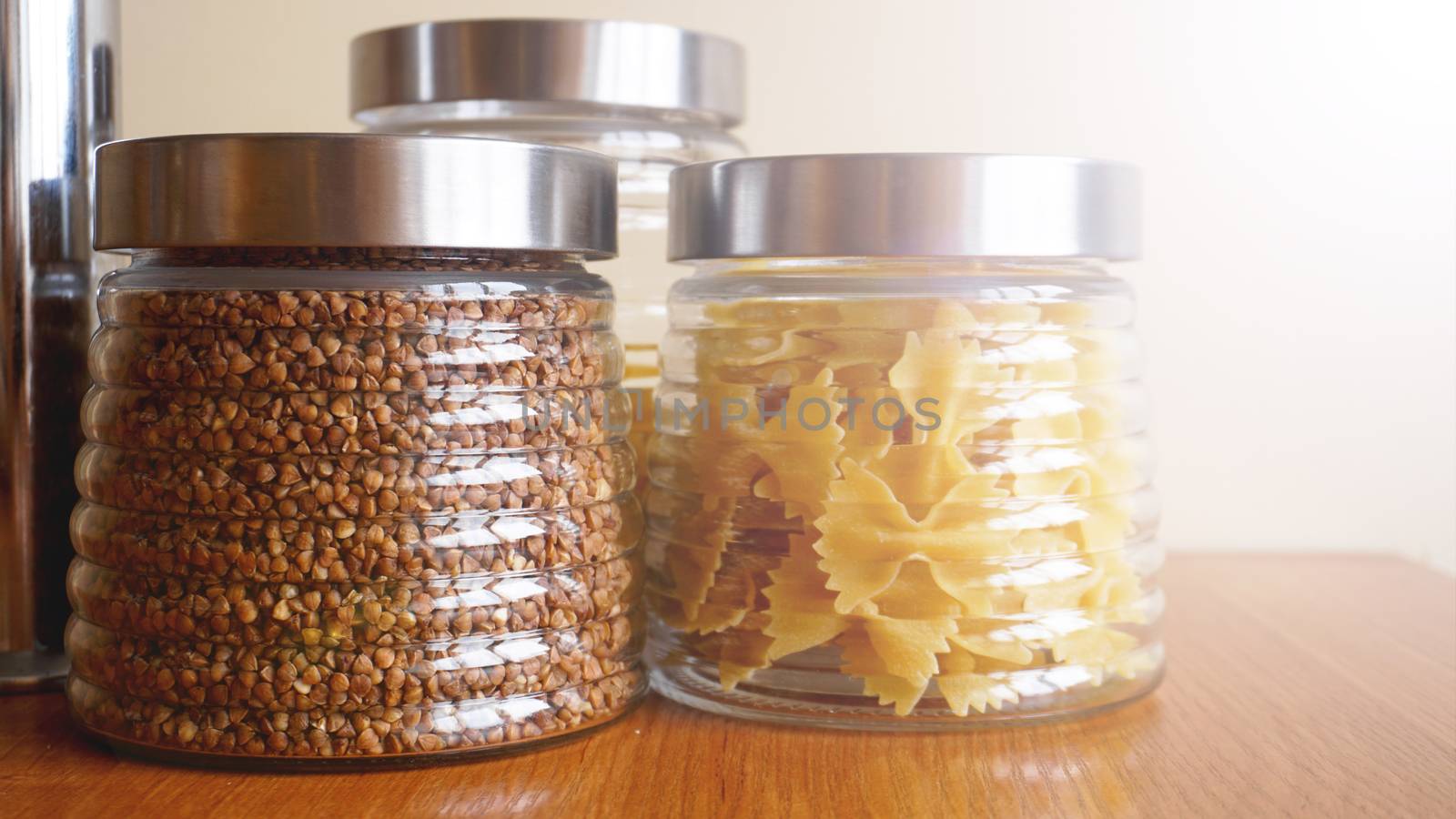 Pasta and bukwheat meals. Healthy cooking in glass containers on wooden table. by natali_brill