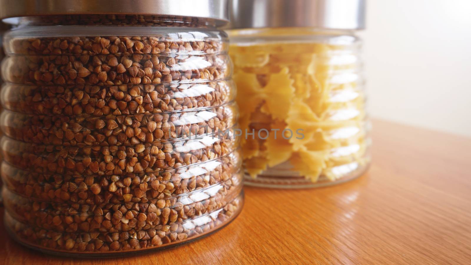 Pasta and bukwheat meals. Healthy cooking in glass containers on wooden table. by natali_brill