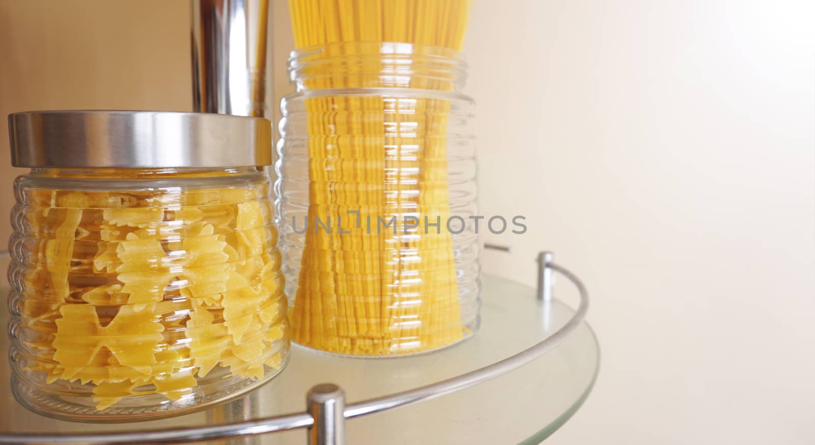 Pasta in a glass jar on light background. Free space for text