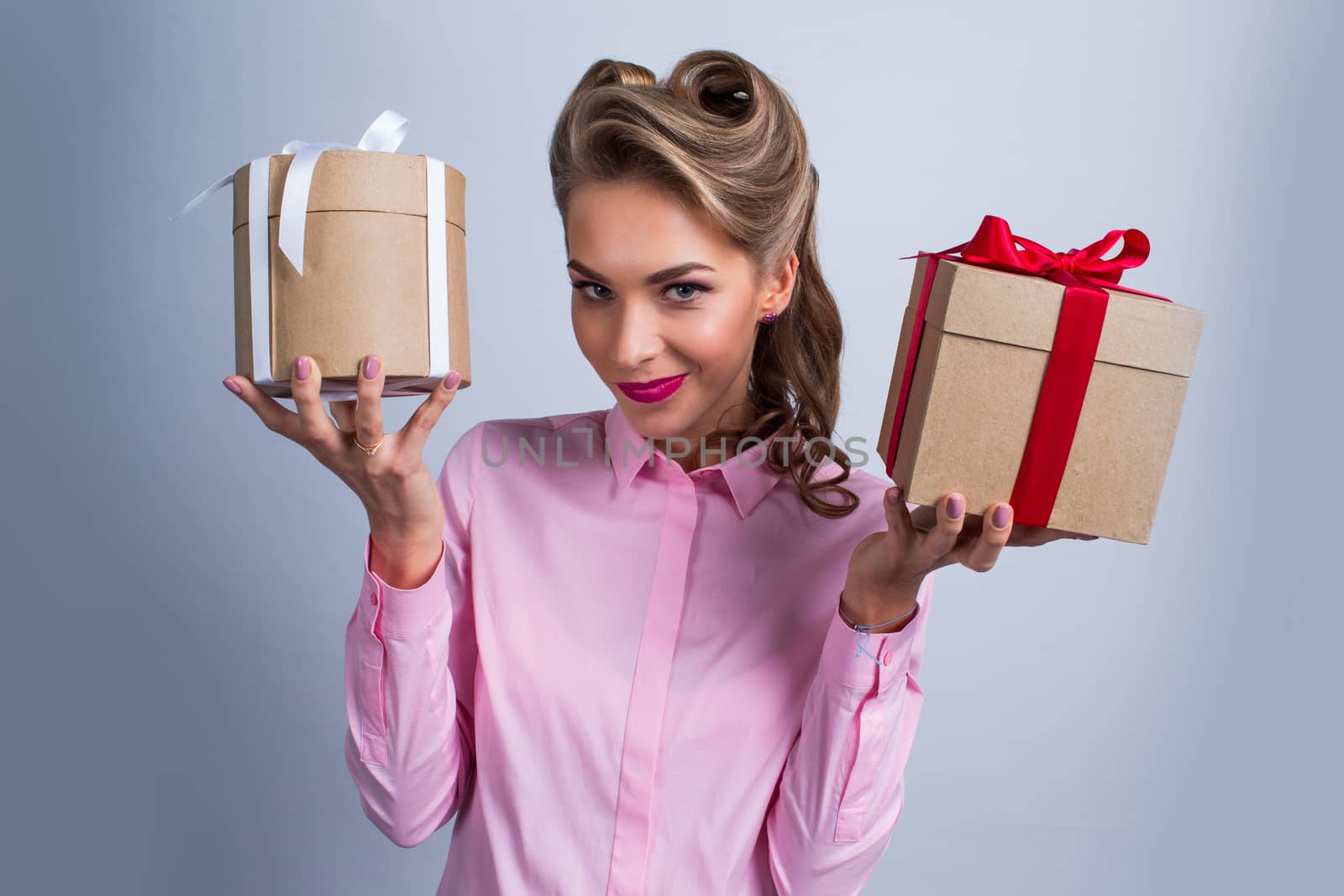 Young happy woman holding two presents with bows