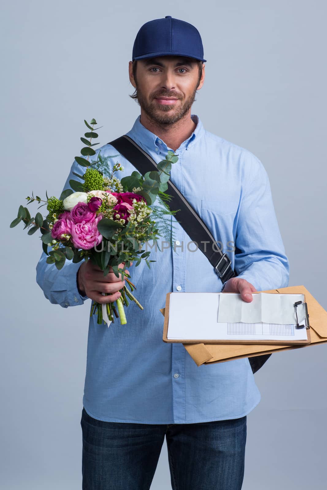 Delivery man holding flower bouquet and form