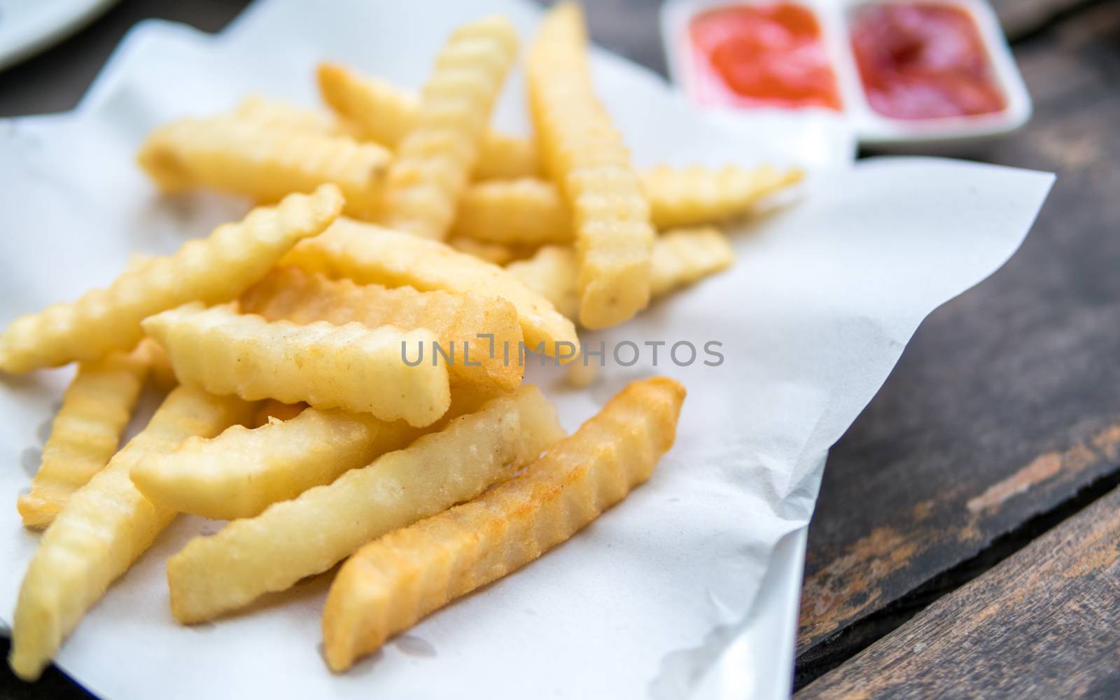 potatoes fries with sauce on a white paper