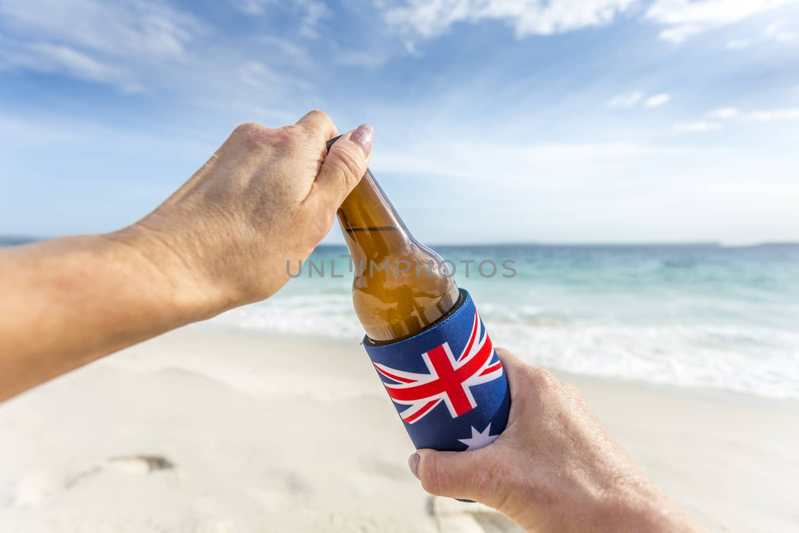 Aussie culture, hands open a cold beer on the beach in summer.  Australian culture, beach party, barbeque, celebrate, holiday, chilling out