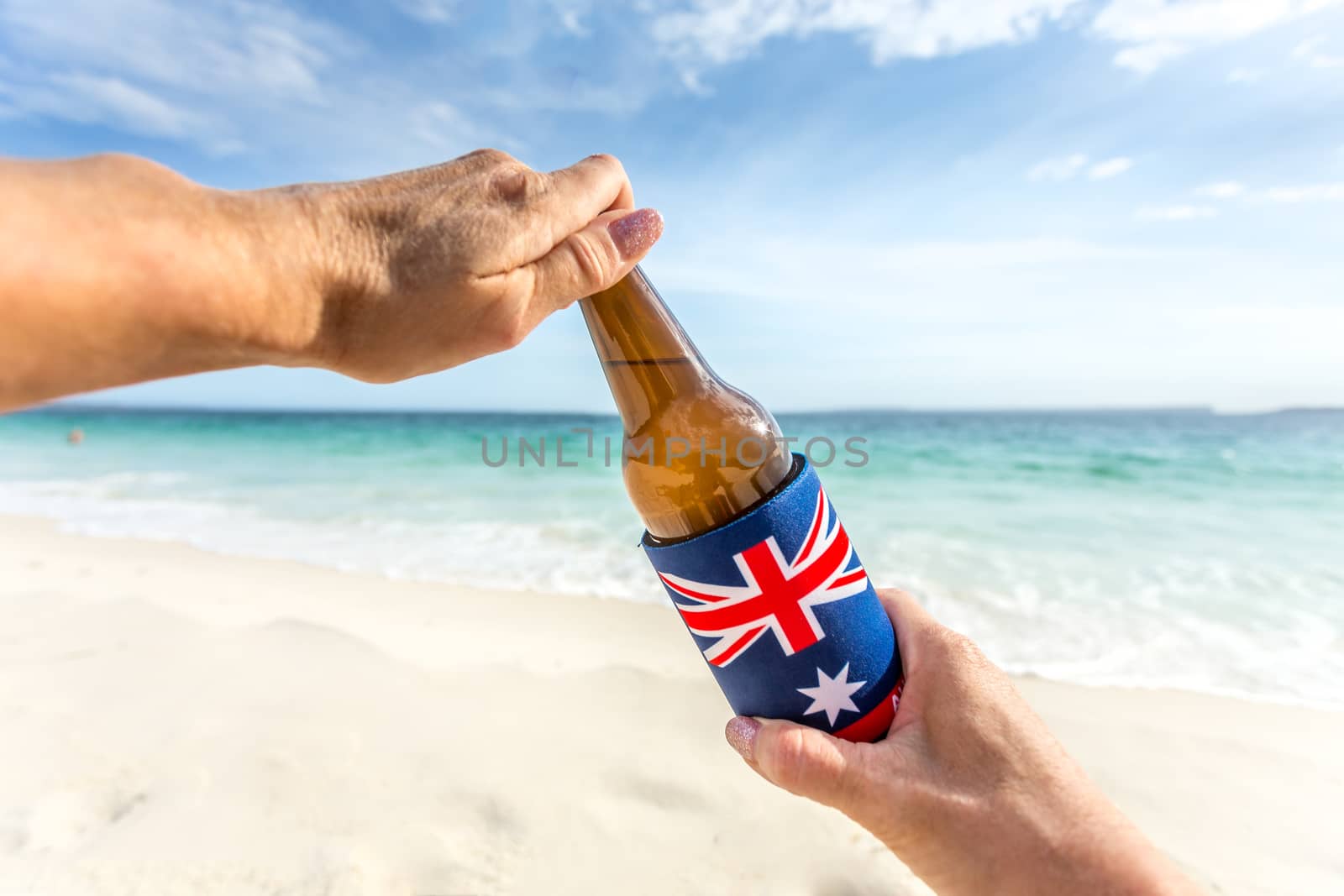 Crack open a cold beer on the beach on a warm sunny summer day.  Chilling out.  Beer bottle in cooler printed with Australian flag