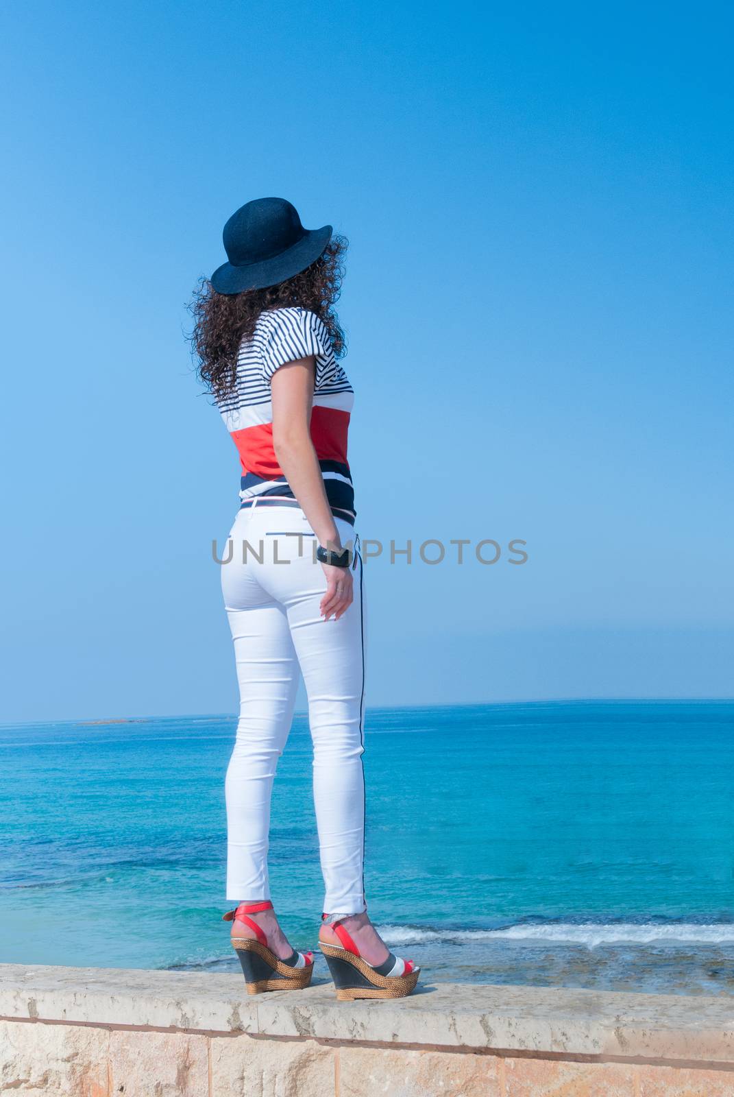The girl in white jeans looks into the sea distance by ben44