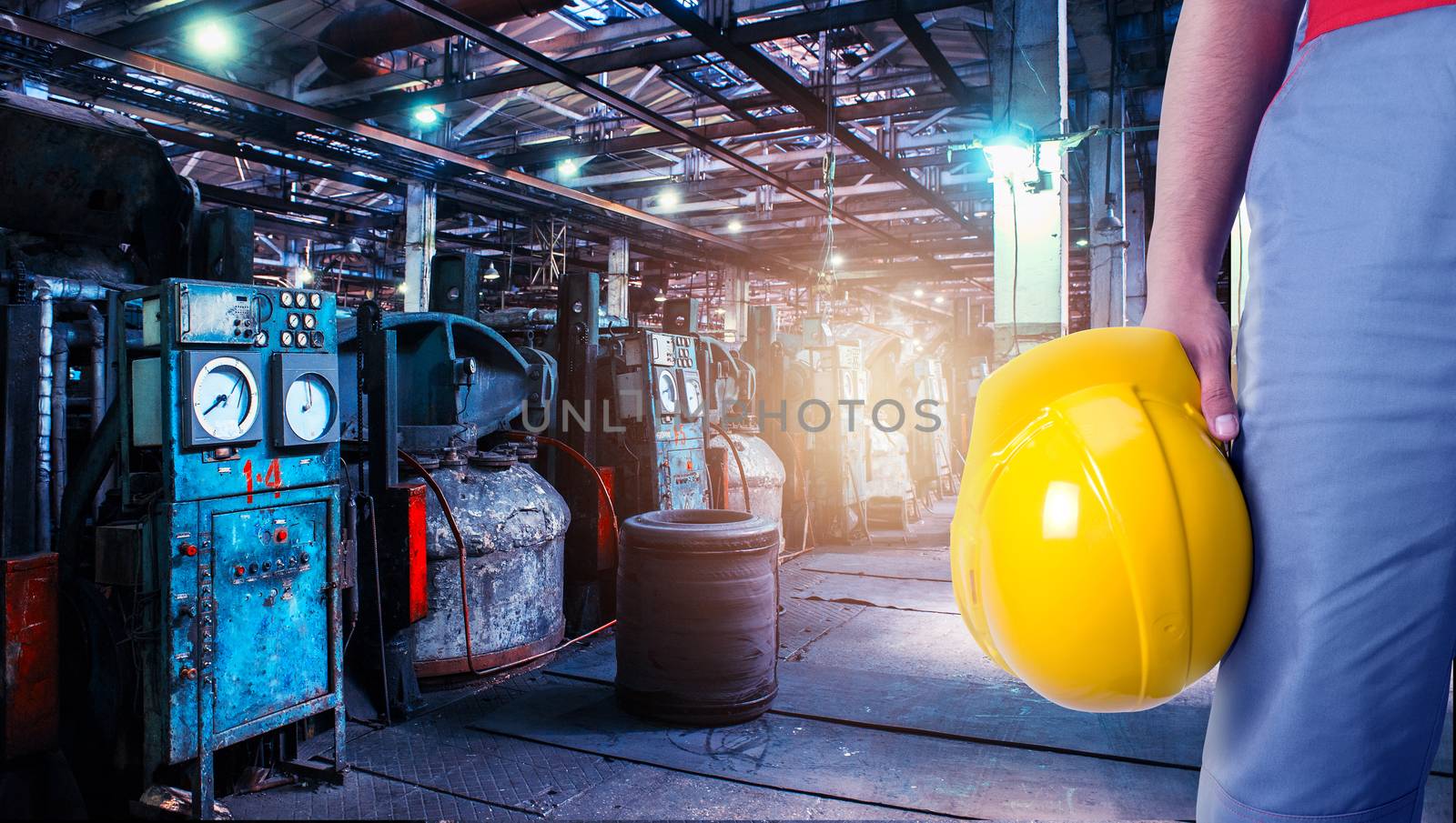 Closeup of worker man with yellow helmet on Industrial zone background, manufacturing facility. Concept of Safe labor in the enterprise.