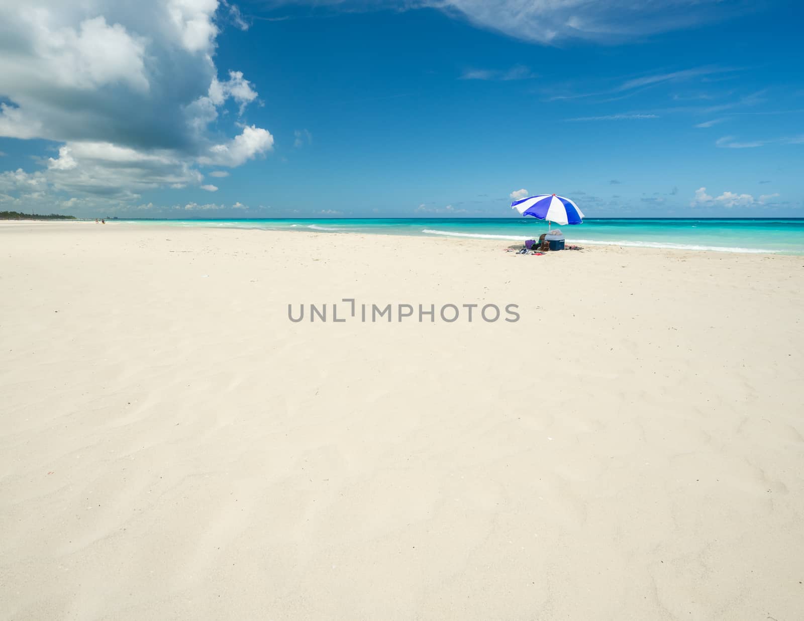 Wonderful  beach of Varadero during a sunny day, fine white sand and turquoise and green Caribbean sea,on the right one blue parasol,Cuba.concept  photo,copy space.