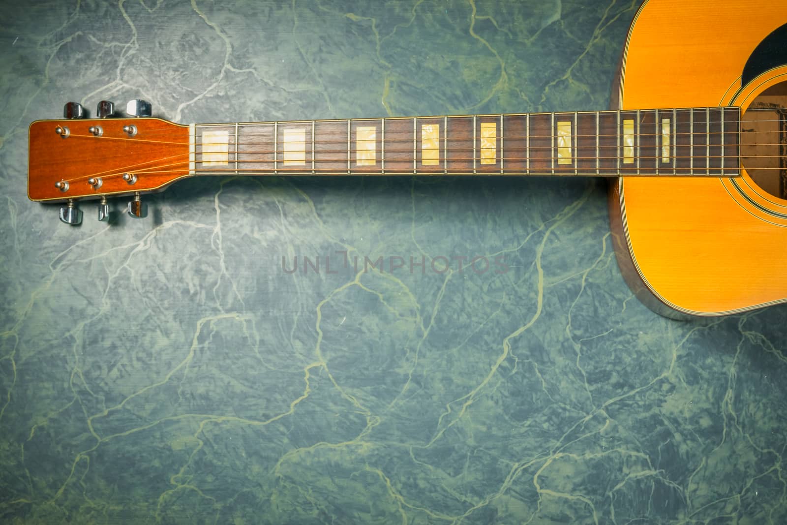 acoustic guitar on green marble background,music concept.