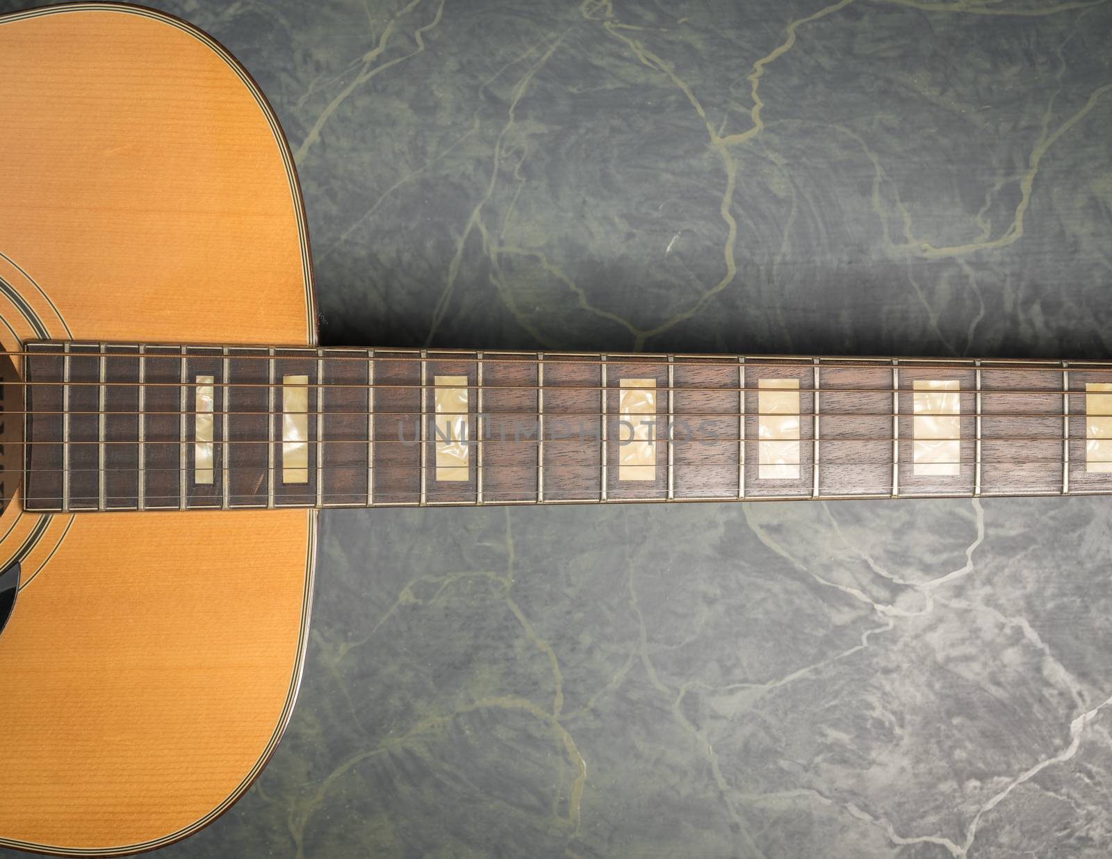 acoustic guitar on marble close up by Robertobinetti70