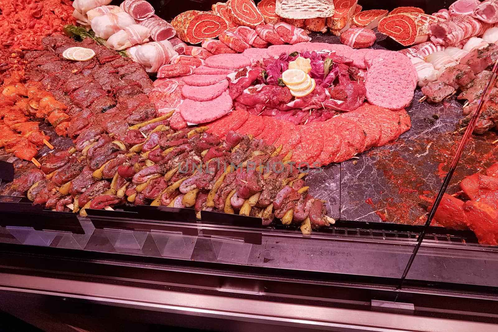 Meat department with typical german raw meat inside a supermarket. Pork chops, fresh sausage and cold cuts in the meat department.