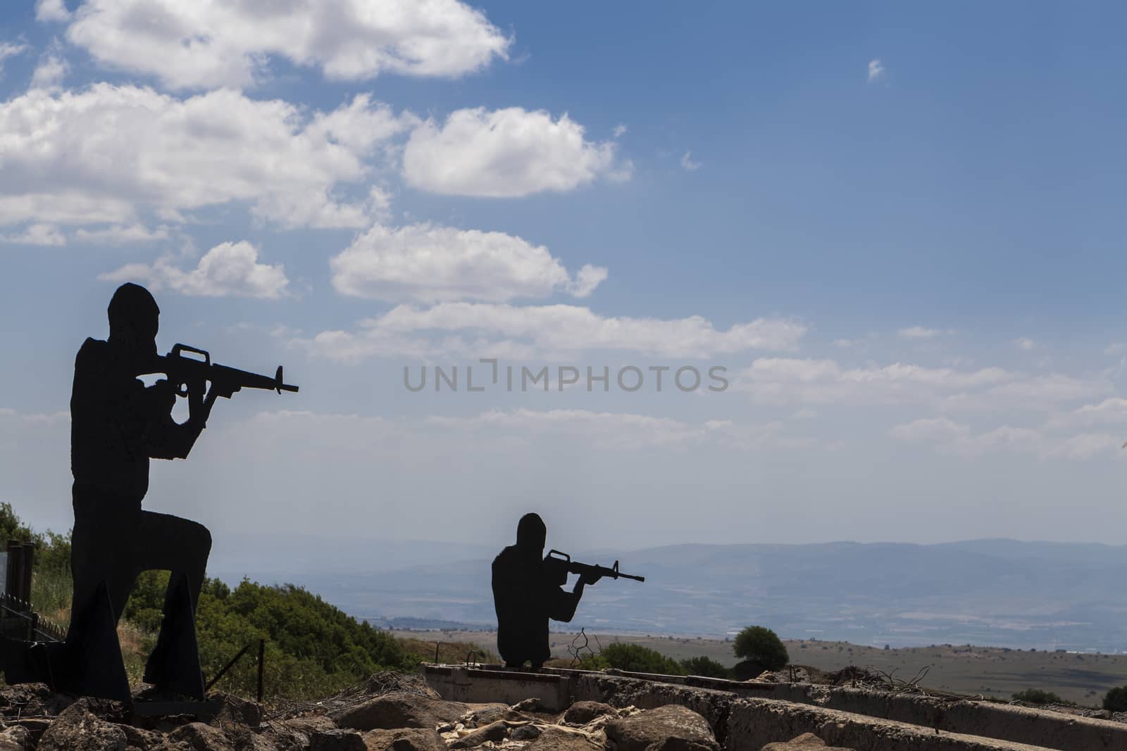 Two Soldiers silhouetts with blue sky in the background and rock reinforments in the foreground