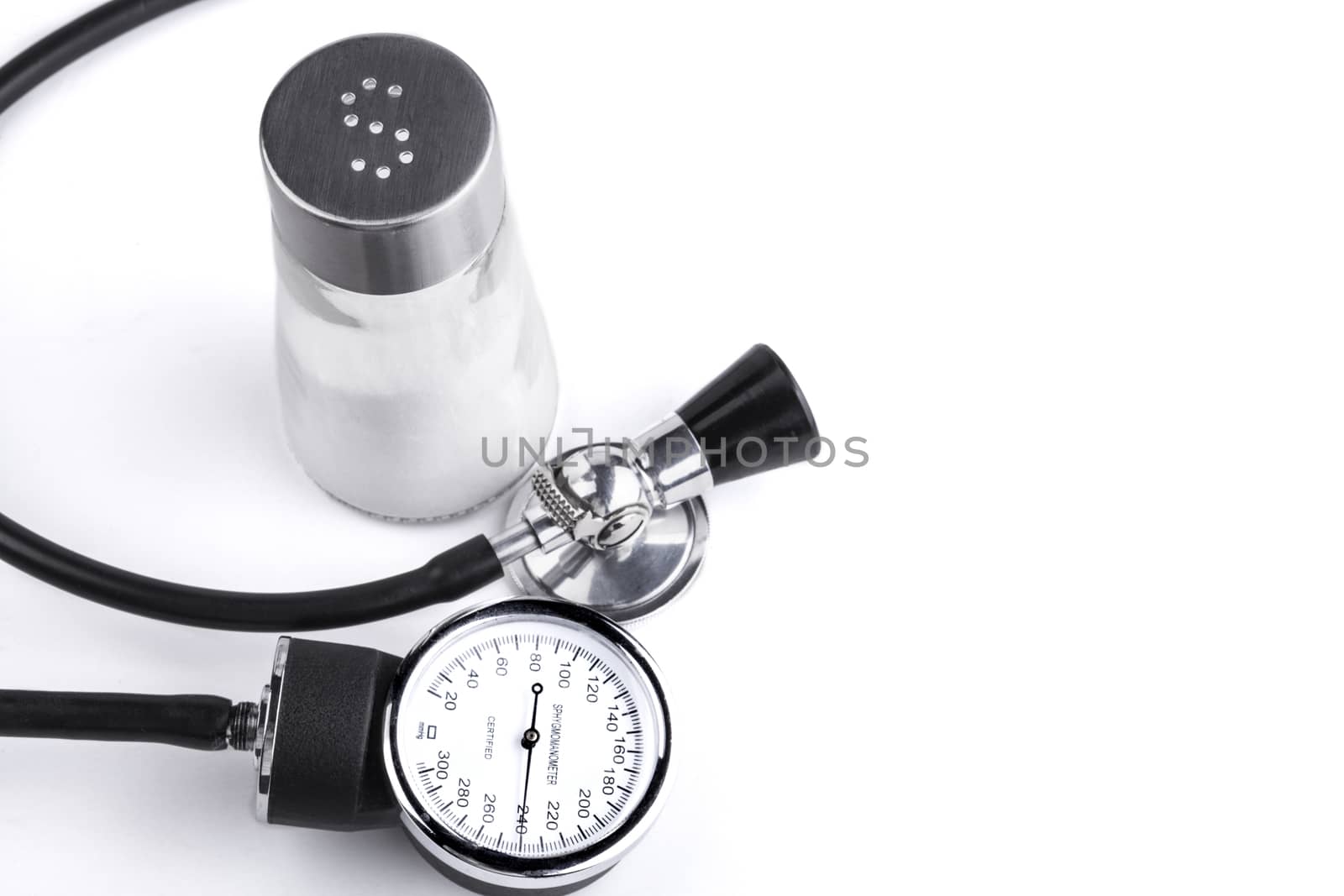 Black sthethoscope and sphygmamanometer with salt in the background isolated on white