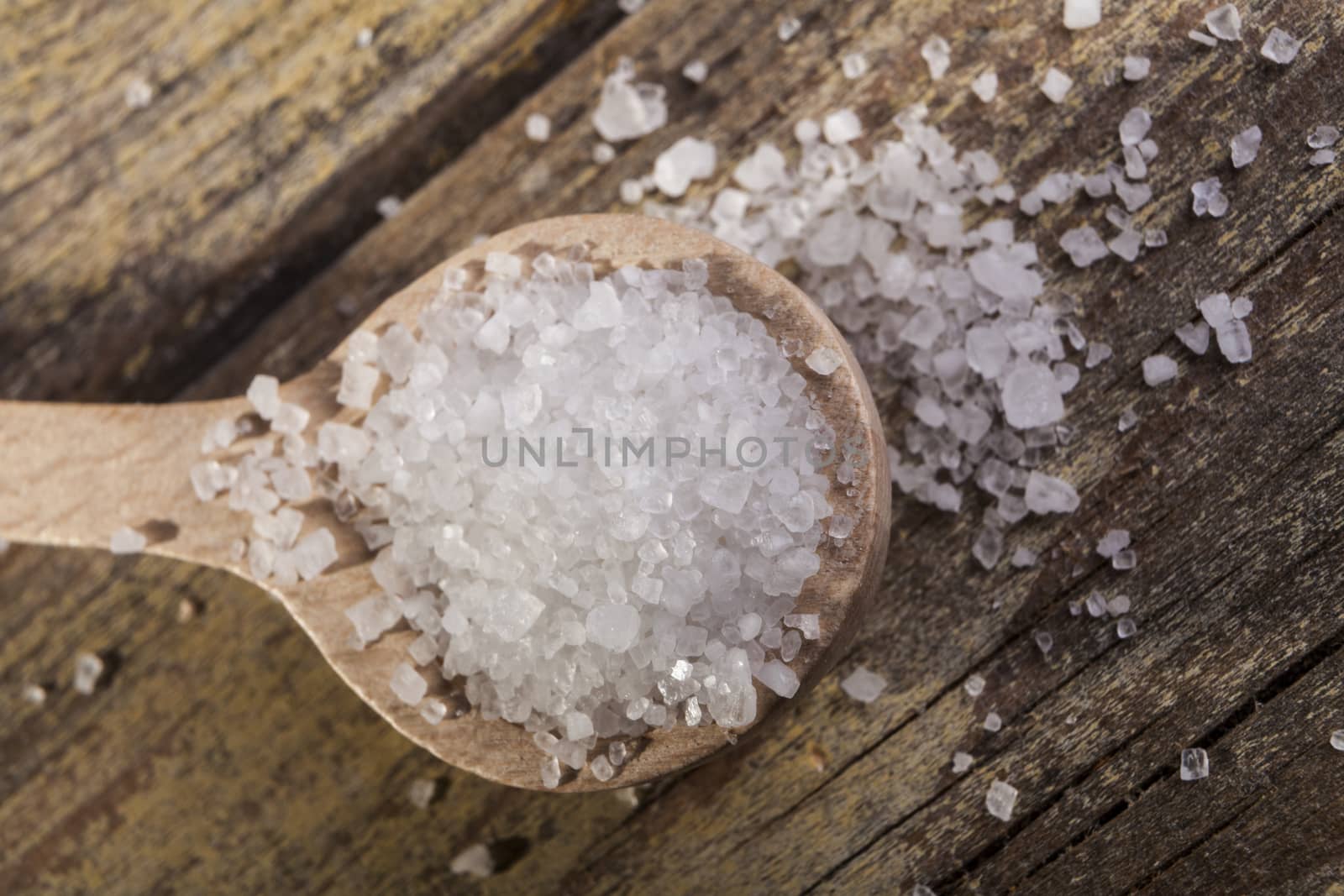 Old Brown wood spoon with salt cristals on wood table