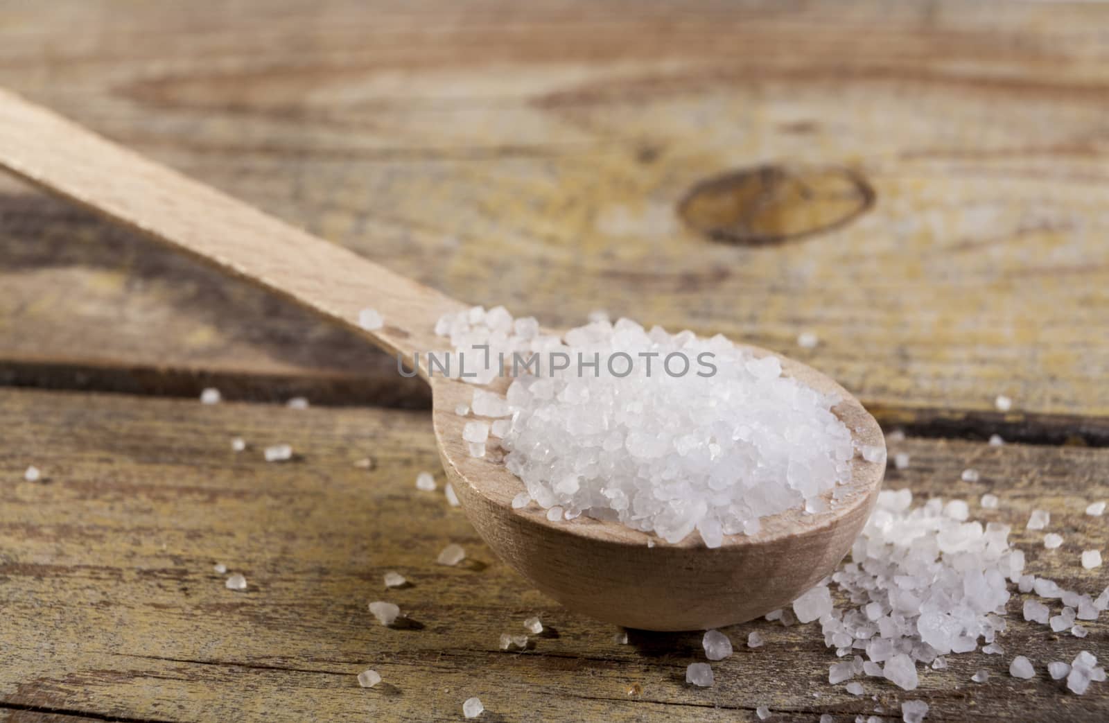 Old Brown wood spoon with salt cristals on wood table