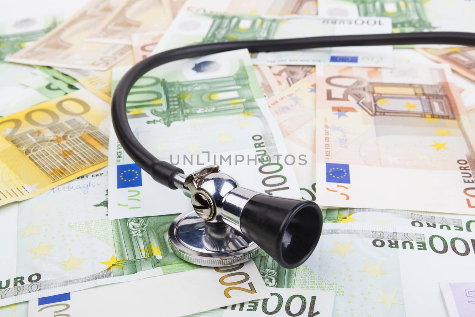 Black stethoscope  on pile of euro banknotes closeup isolated on white background