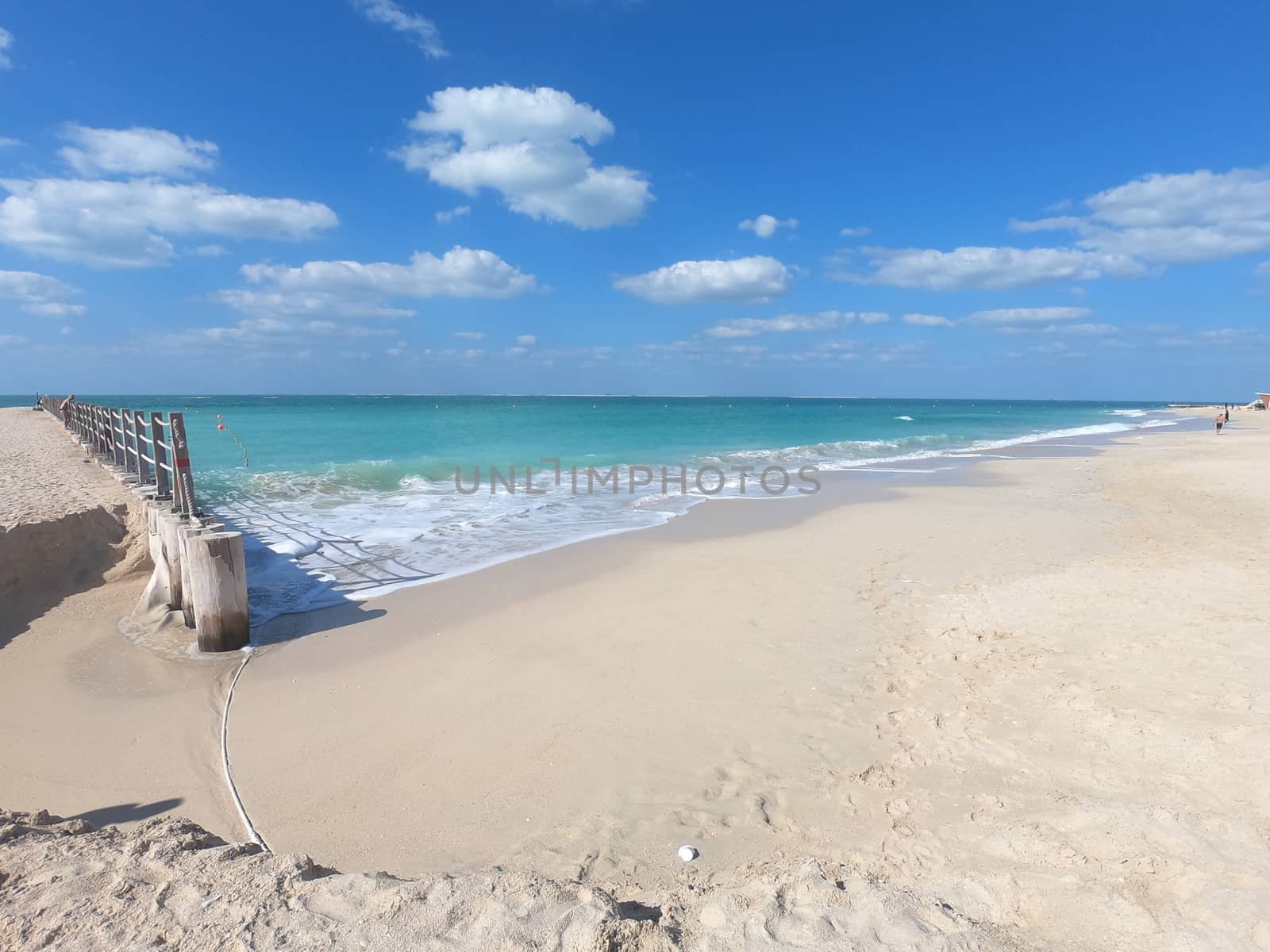 View of Pier at Beach in Dubai with clear blue water and white sand