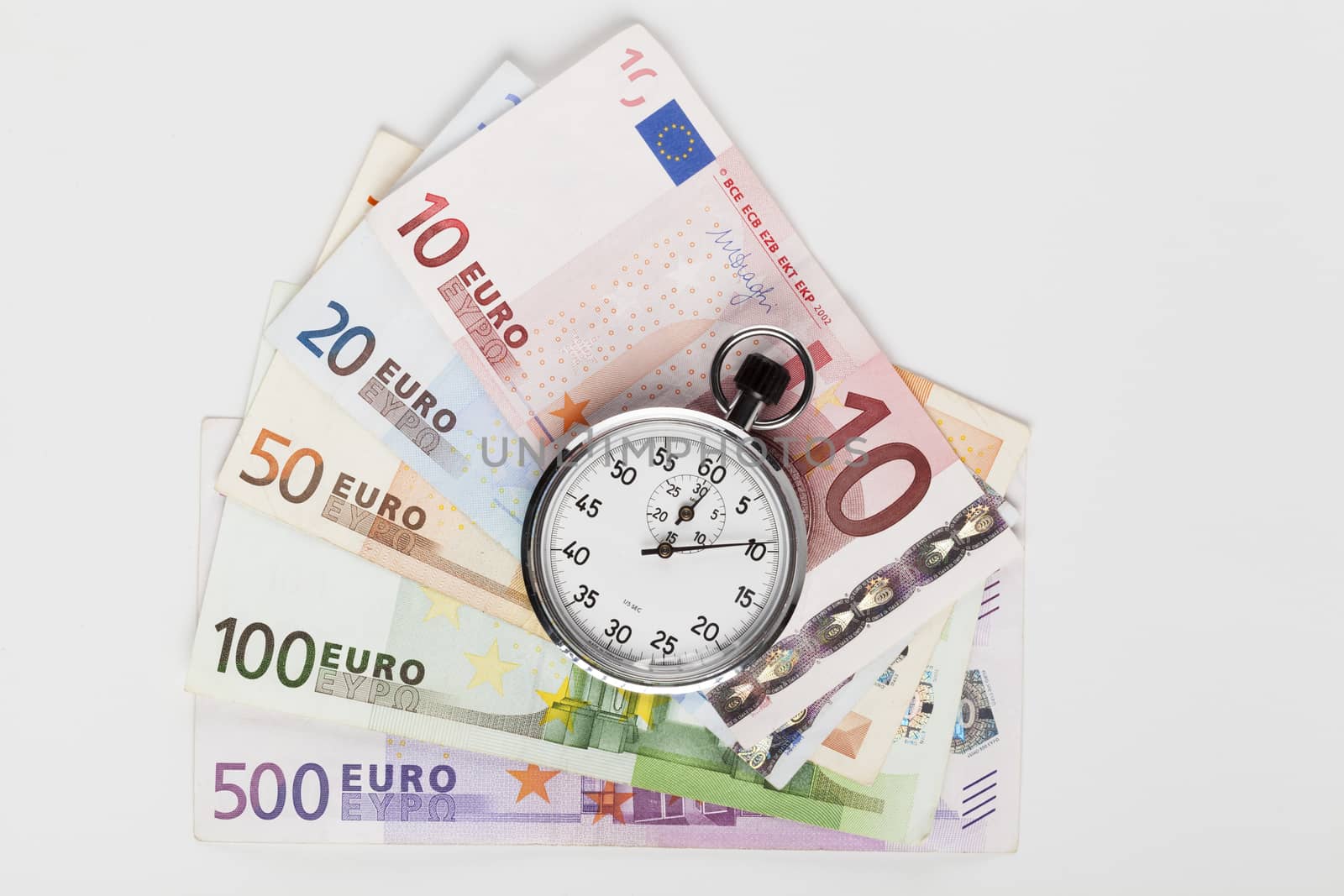 Different euro banknotes with silver analog stopwatch