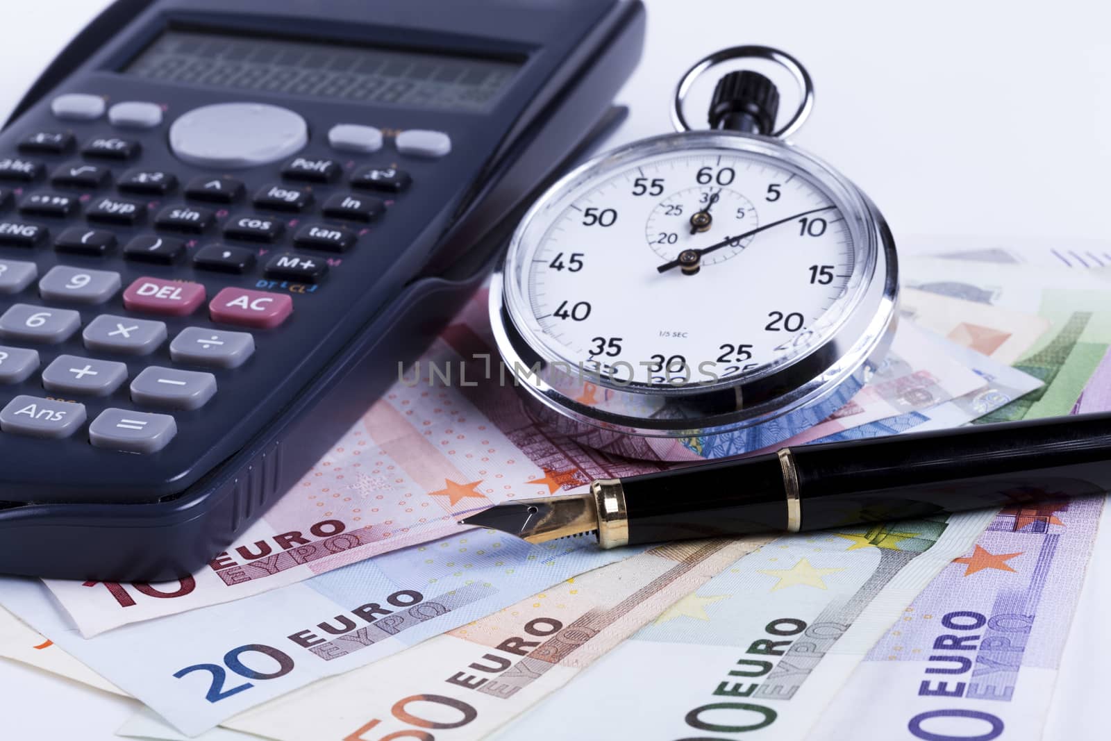 Euro banknotes on white background with black calculator and silver analog stopwatch