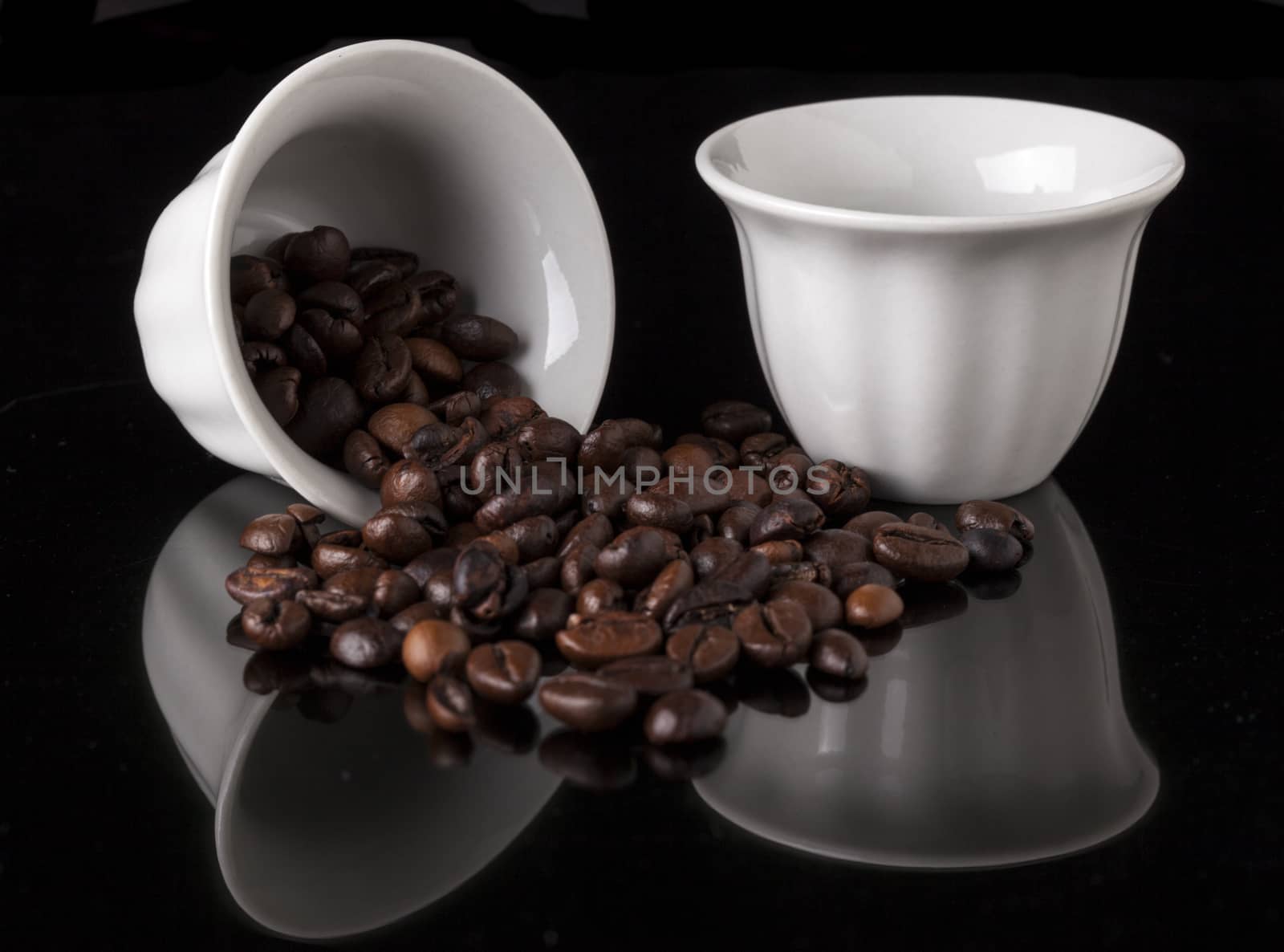 Pair Of White traditional arabic small coffee cup on black background with reflection and coffee Beans