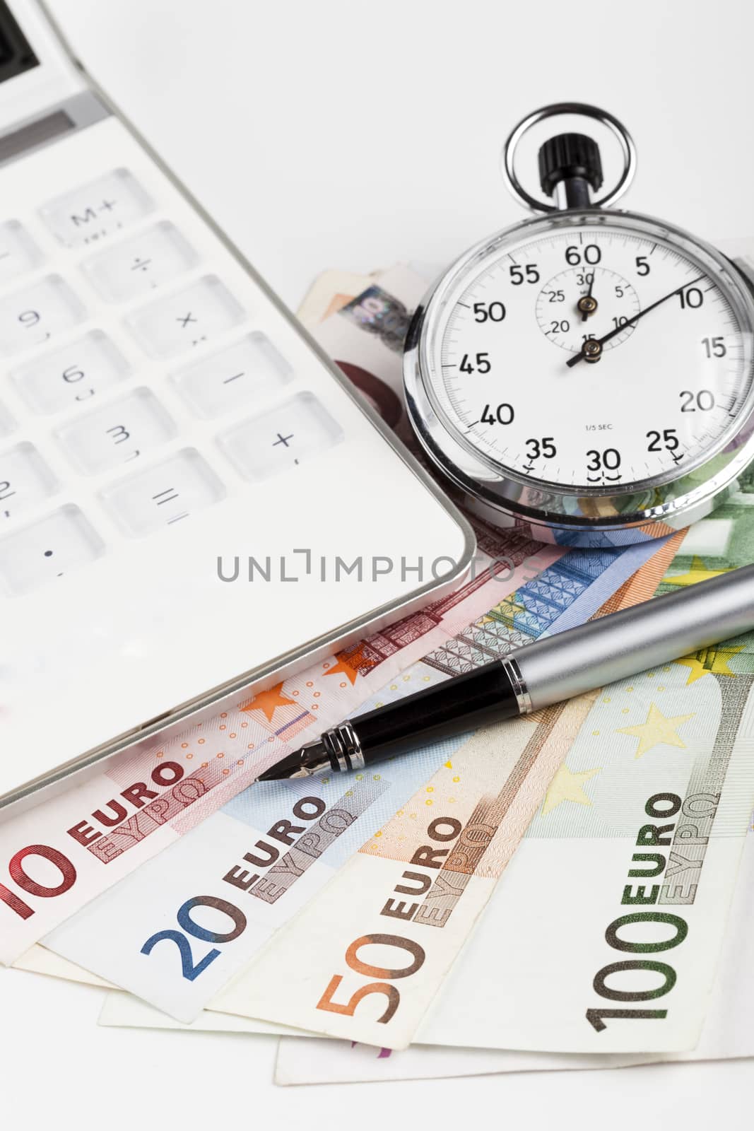 Euro banknotes on white background with white calculator and silver analog stopwatch and fountain pen