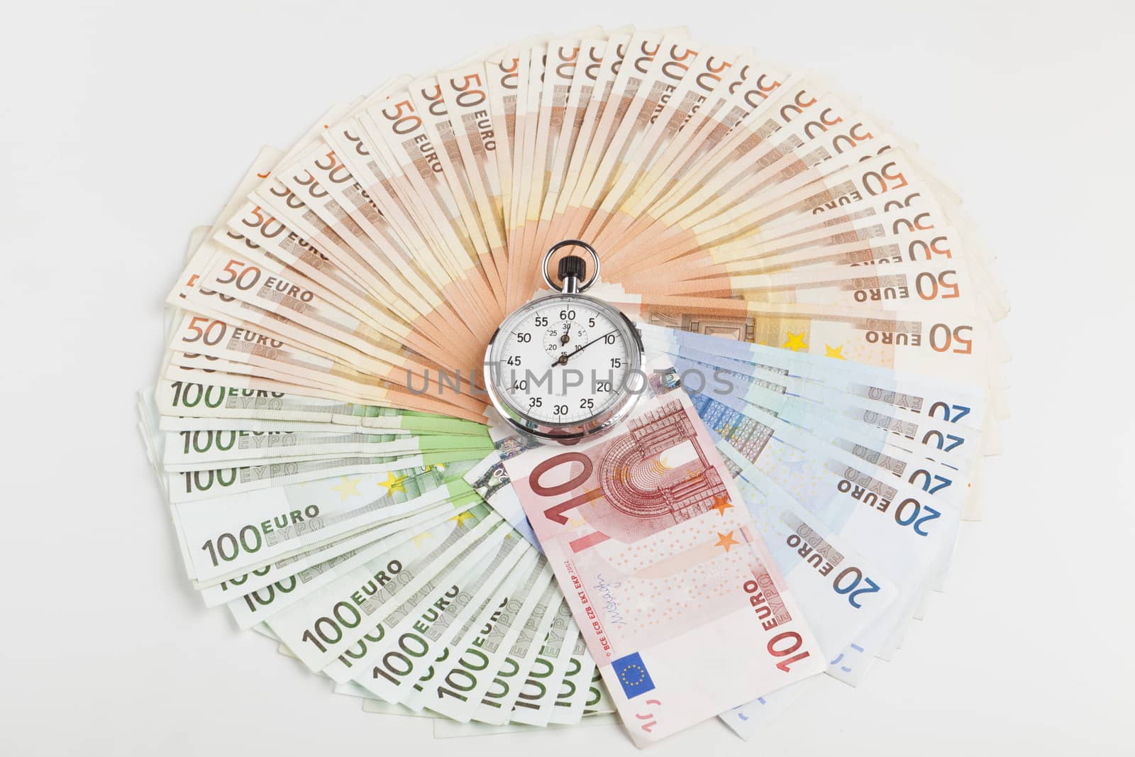Circle made of euro banknotes with silver analog stopwatch in the middle