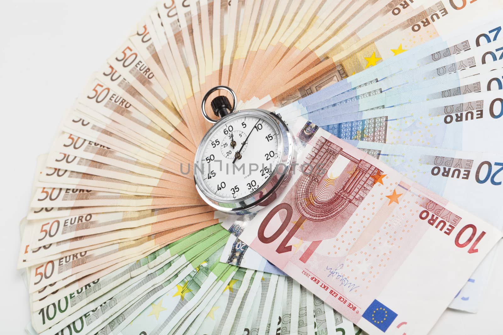 Silver analog stopwatch in a middle of euro banknotes circle