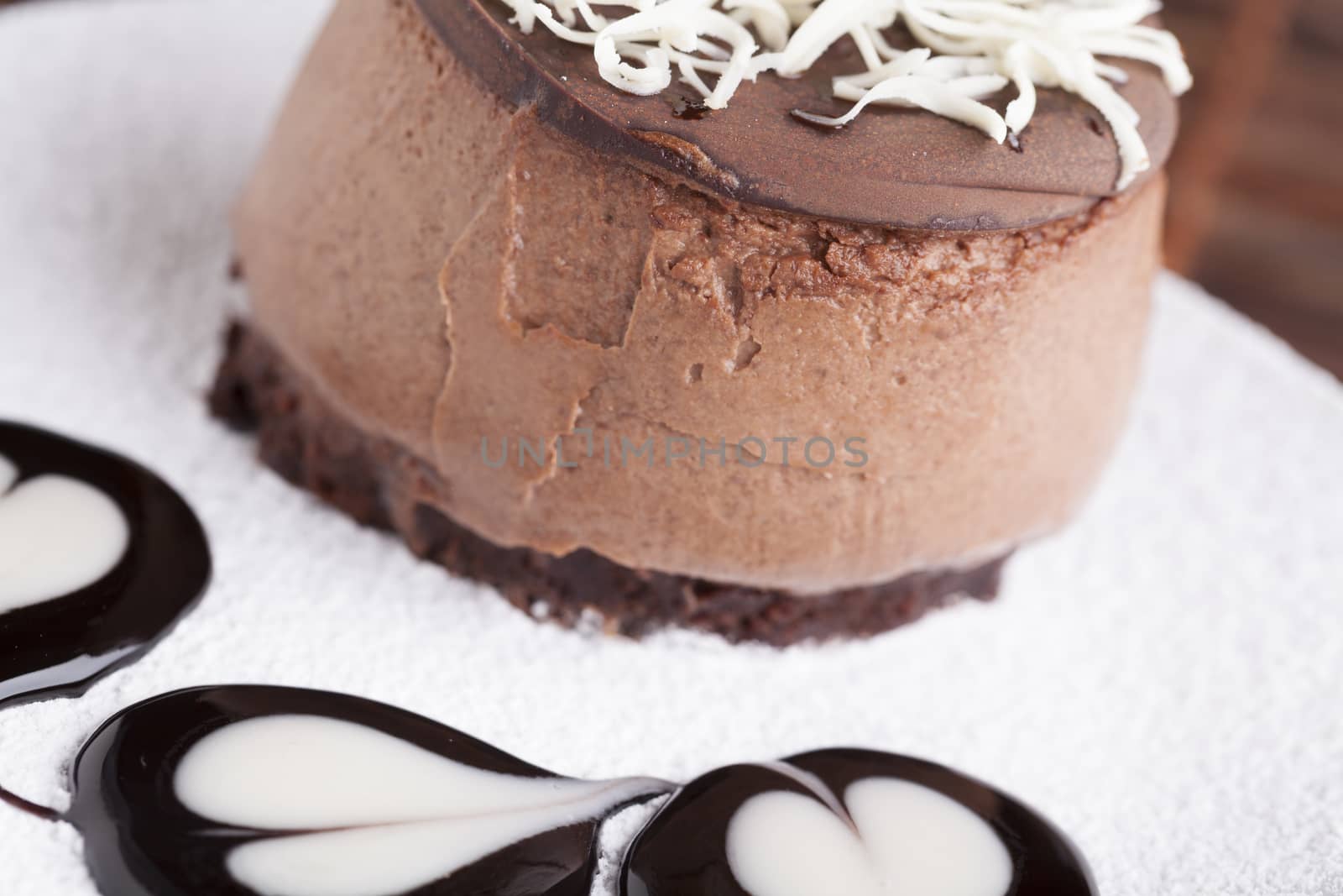 Brown Chocolate mousse cake with whie chocolate on top and heart chocolate shape on suggar powder