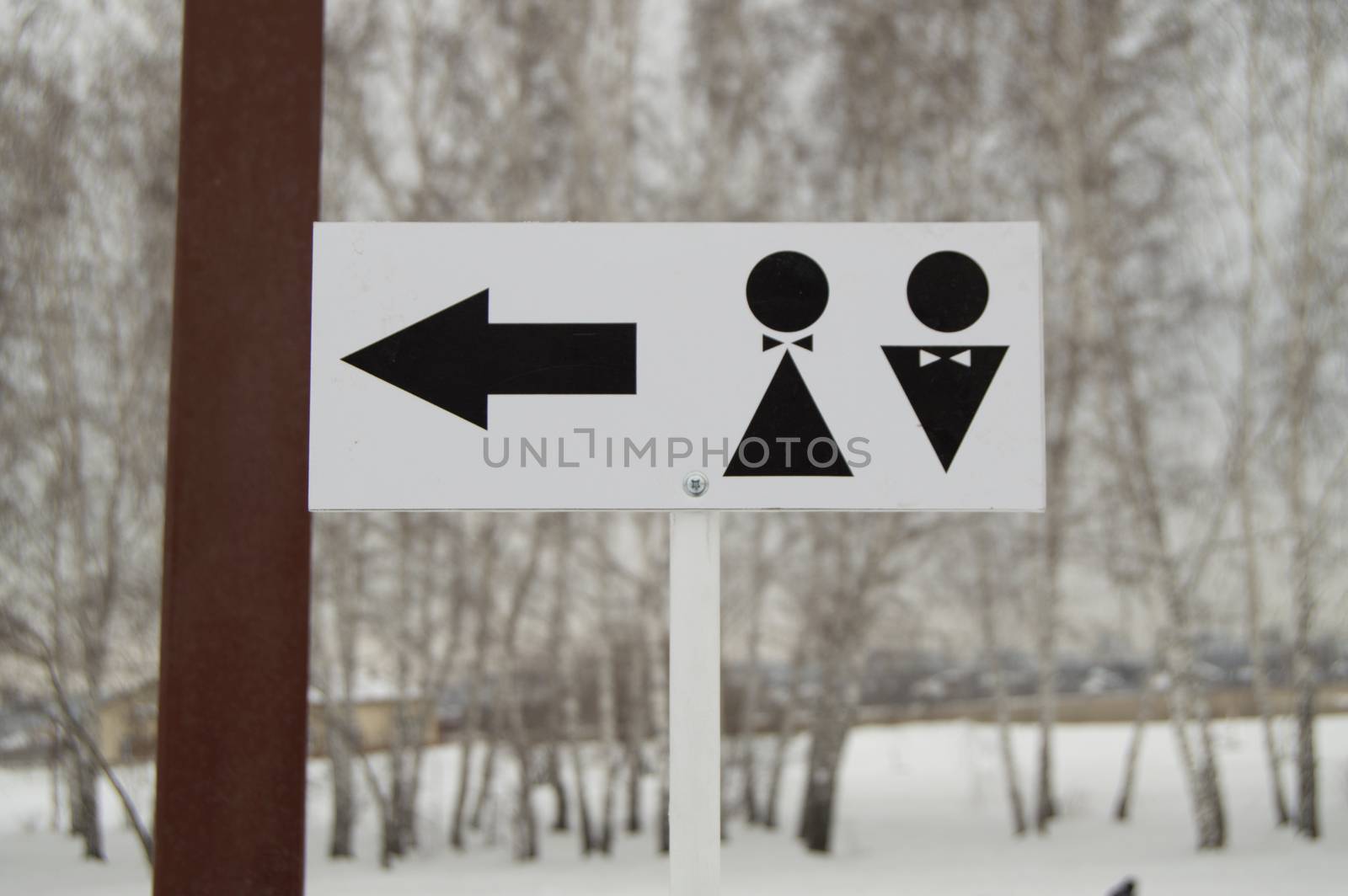 A pointer to a public toilet and the sign of a man and a woman. Hygiene in the Park, outdoor.