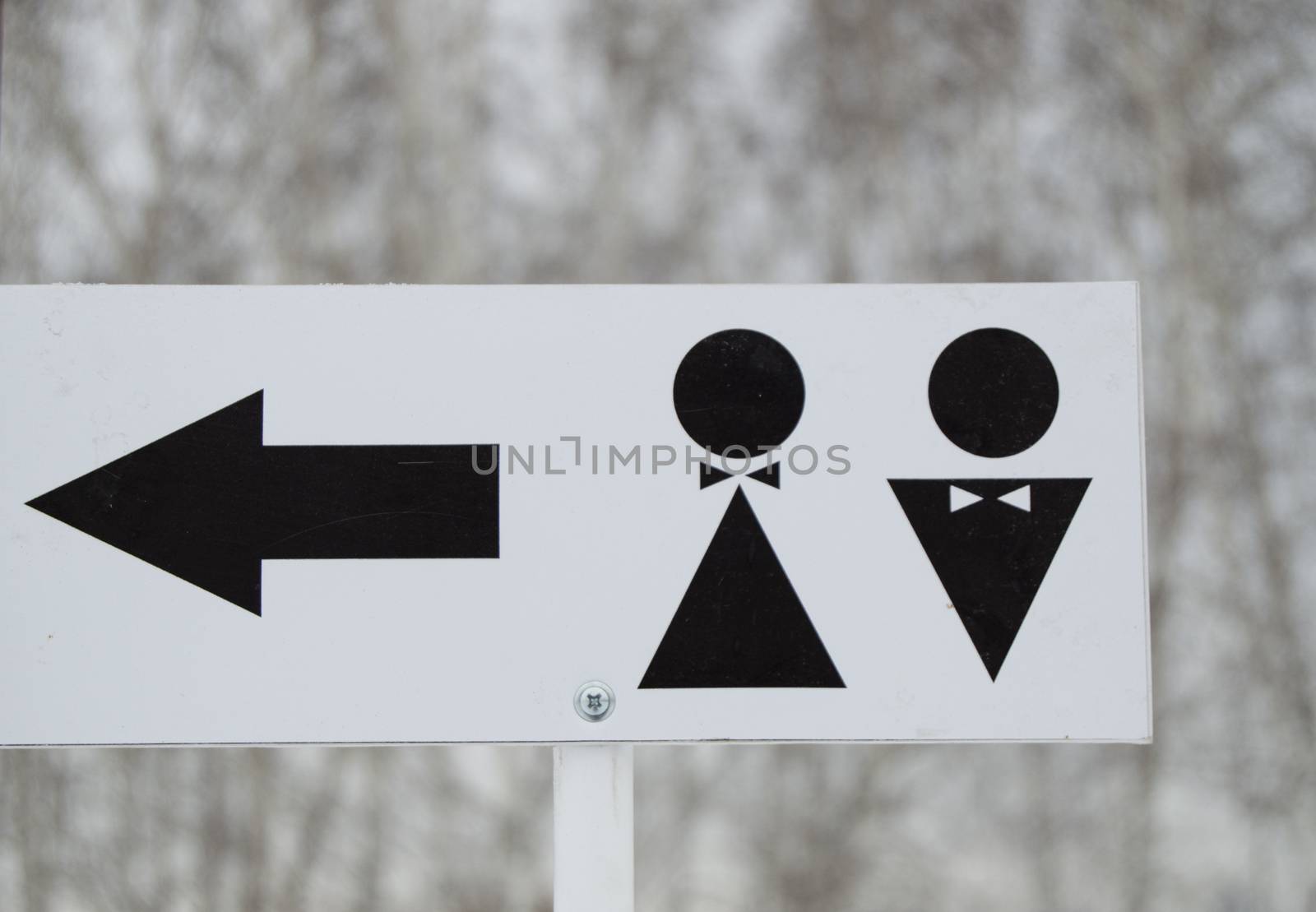 A pointer to a public toilet and the sign of a man and a woman. Hygiene in the Park, outdoor.