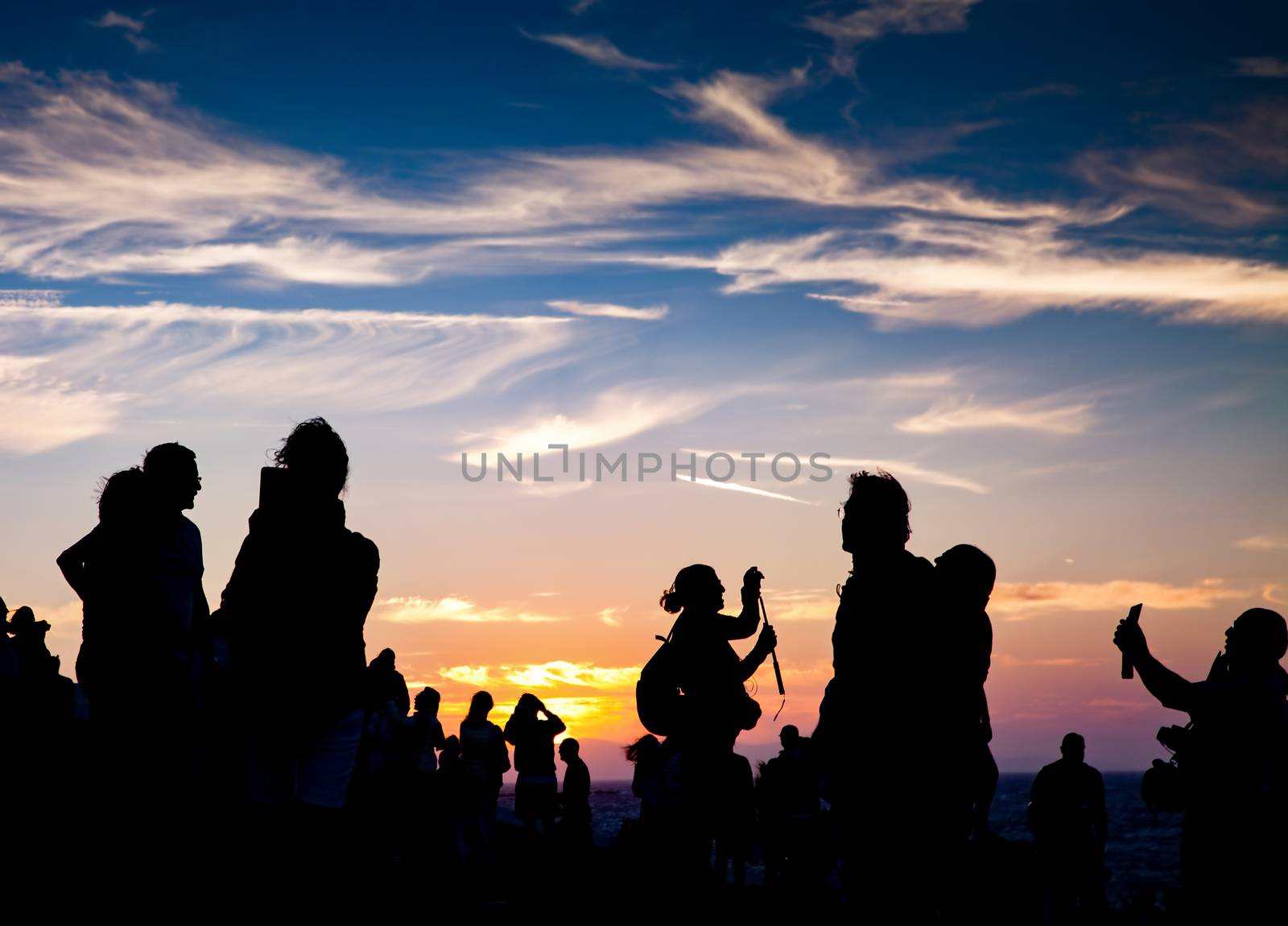 silhouettes of people taking pictures with smartphones