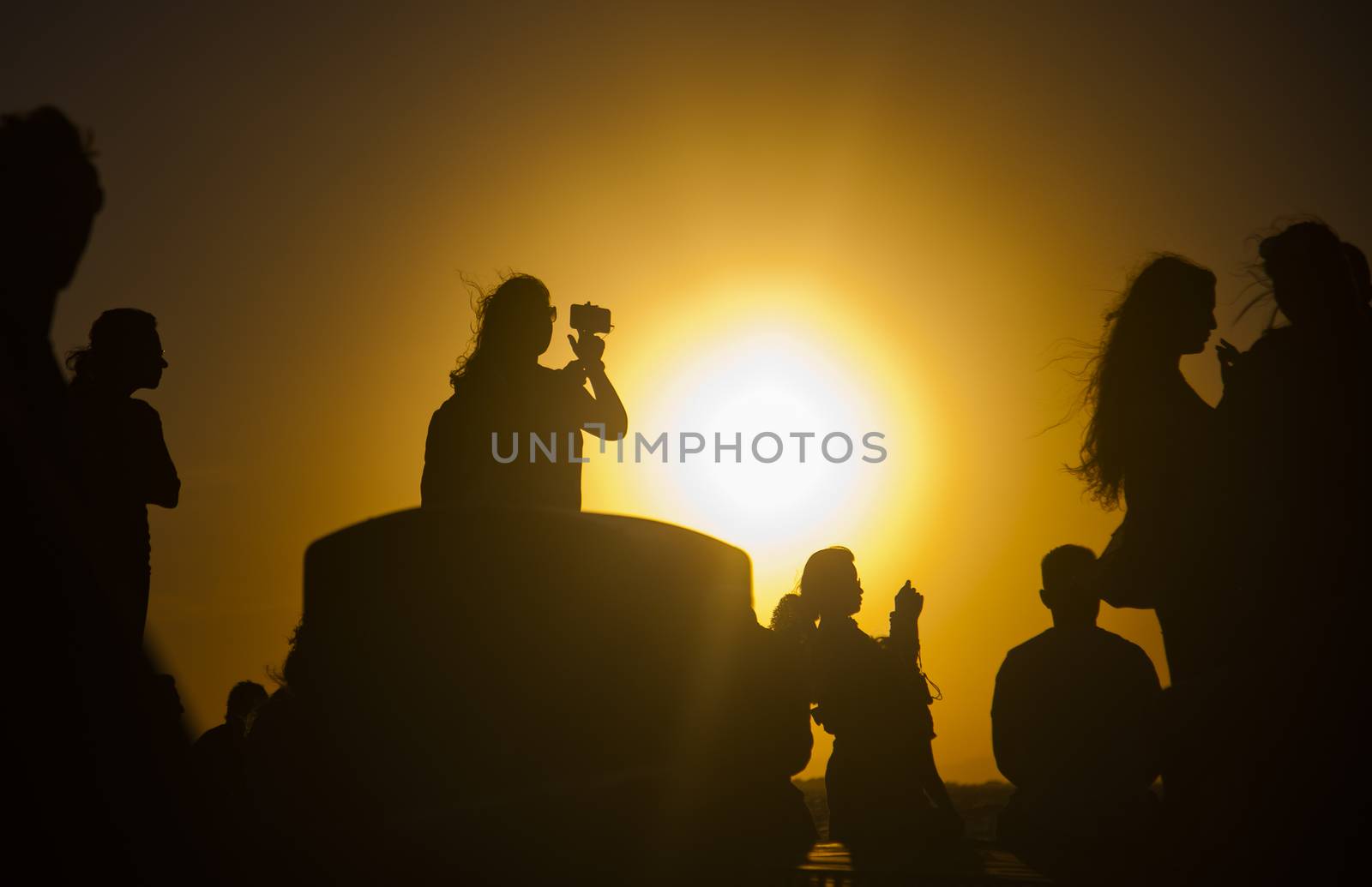 silhouettes of people taking pictures with smartphones