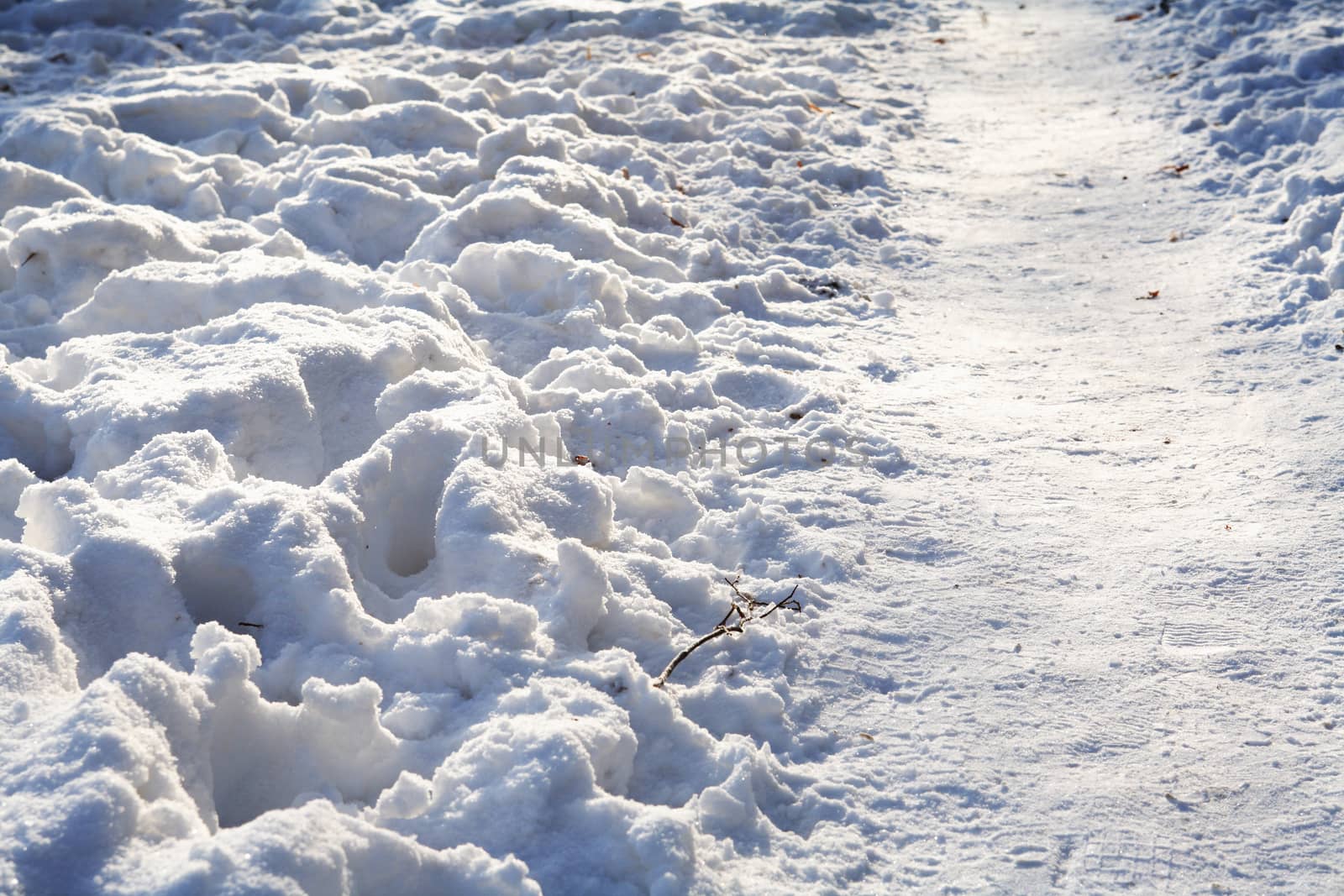 Winter background with footpath across snow