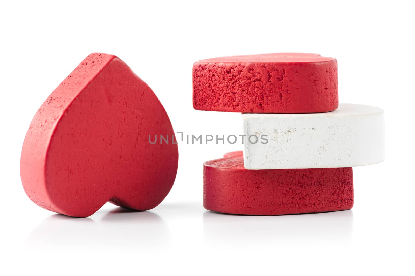 Red and white roughly carved wooden hearts isolated on white