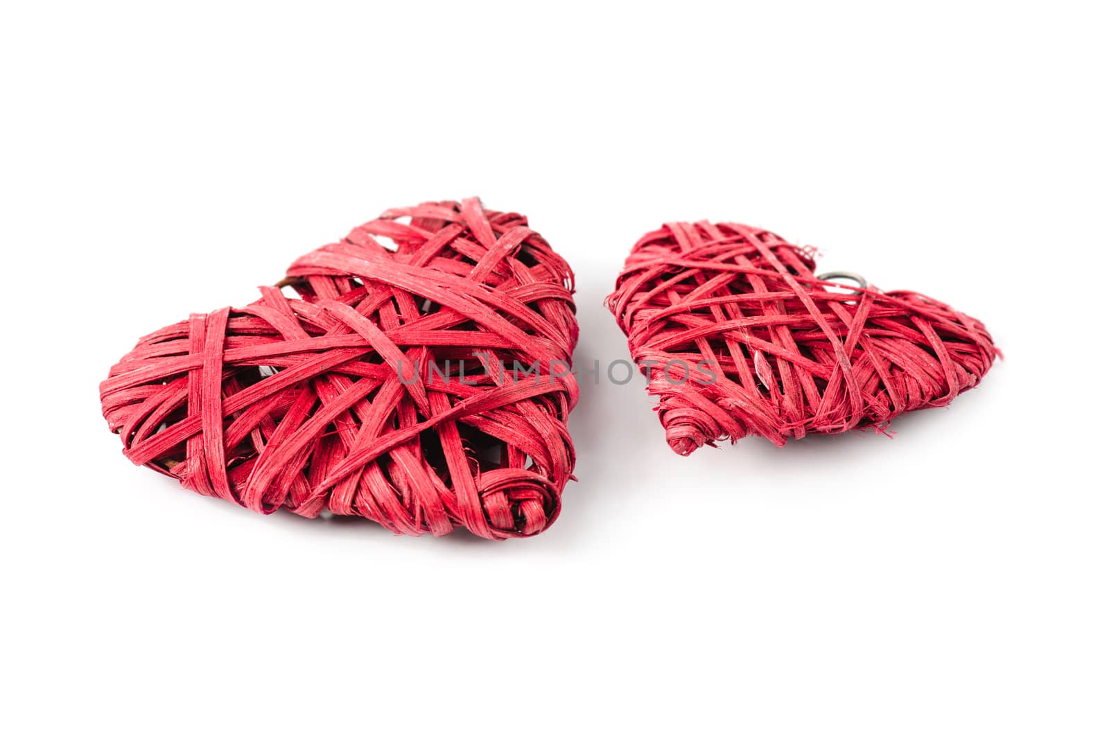 Two red hearts made of straw isolated on white, bigger and smaller one