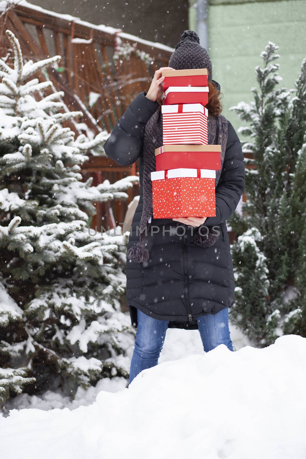 woman returning home from shopping holding pile of christmas pre by melis