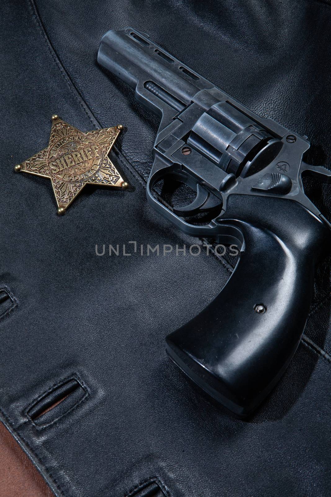 Star badge and revolver on a studio background