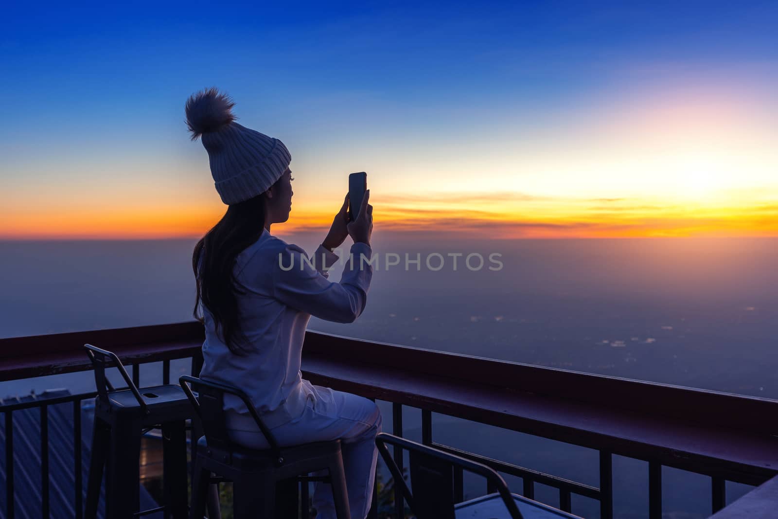 Woman taking photos of sunrise.